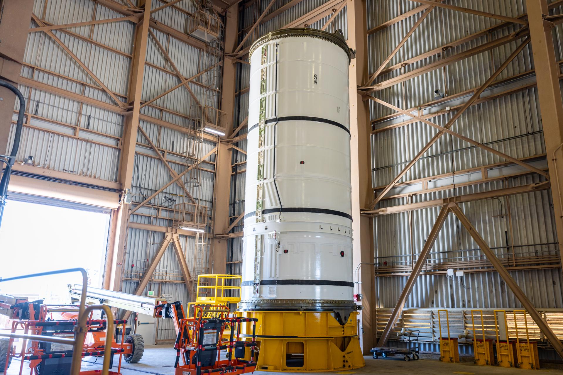 The left-hand forward solid rocket booster segment for NASA’s Artemis III SLS (Space Launch System) rocket is removed from its shipping container ahead of processing inside the Rotation, Processing and Surge Facility at the agency’s Kennedy Space Center in Florida on Wednesday, April 15, 2026. The SLS rocket’s twin boosters, manufactured by Northrop Grumman in Utah, will provide more than 75 percent of the SLS rocket’s total thrust at launch. The Artemis III mission will launch crew in the Orion spacecraft on top of the SLS rocket to test rendezvous and docking capabilities between Orion and commercial spacecraft needed to land astronauts on the Moon. 