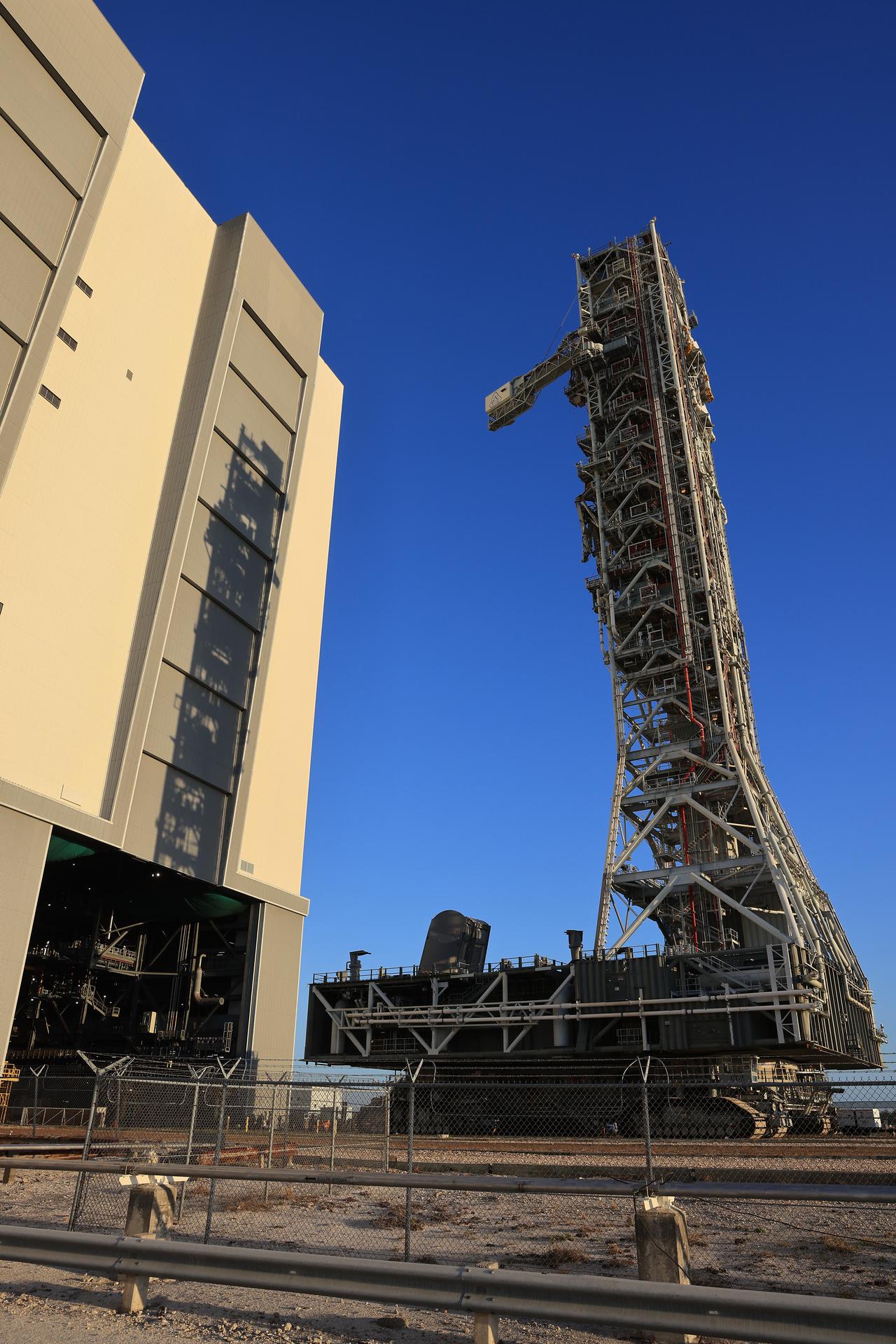 NASA’s mobile launcher approaches the Vehicle Assembly Building following its approximately 4-mile trek from Launch Complex 39B at the agency’s Kennedy Space Center in Florida on Friday, April 17, 2026, in preparation for Artemis III stacking operations. Teams will perform checkouts, inspections, and data analysis, and make repairs to the tower that saw damage during launch of NASA’s Artemis II test flight on April 1, 2026.  