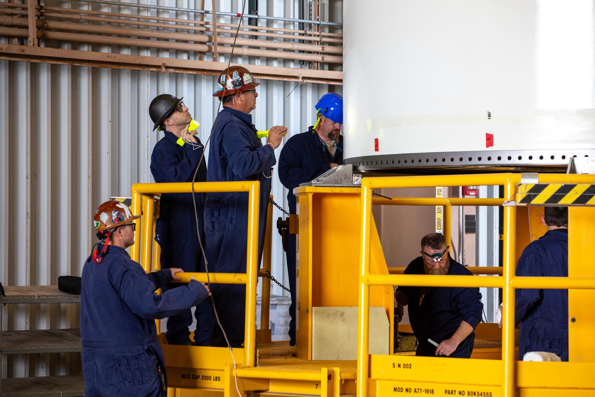 The left-hand forward solid rocket booster segment for NASA’s Artemis III SLS (Space Launch System) rocket is offloaded from its rail car transportation container and inspected ahead of processing inside the Rotation, Processing and Surge Facility at the agency’s Kennedy Space Center in Florida on Tuesday, June 30, 2026. The SLS rocket’s twin boosters, manufactured by Northrop Grumman in Utah, will provide more than 75 percent of the SLS rocket’s total thrust at launch. The Artemis III mission will launch crew in the Orion spacecraft on top of the SLS rocket to test rendezvous and docking capabilities between Orion and commercial spacecraft needed to land astronauts on the Moon.