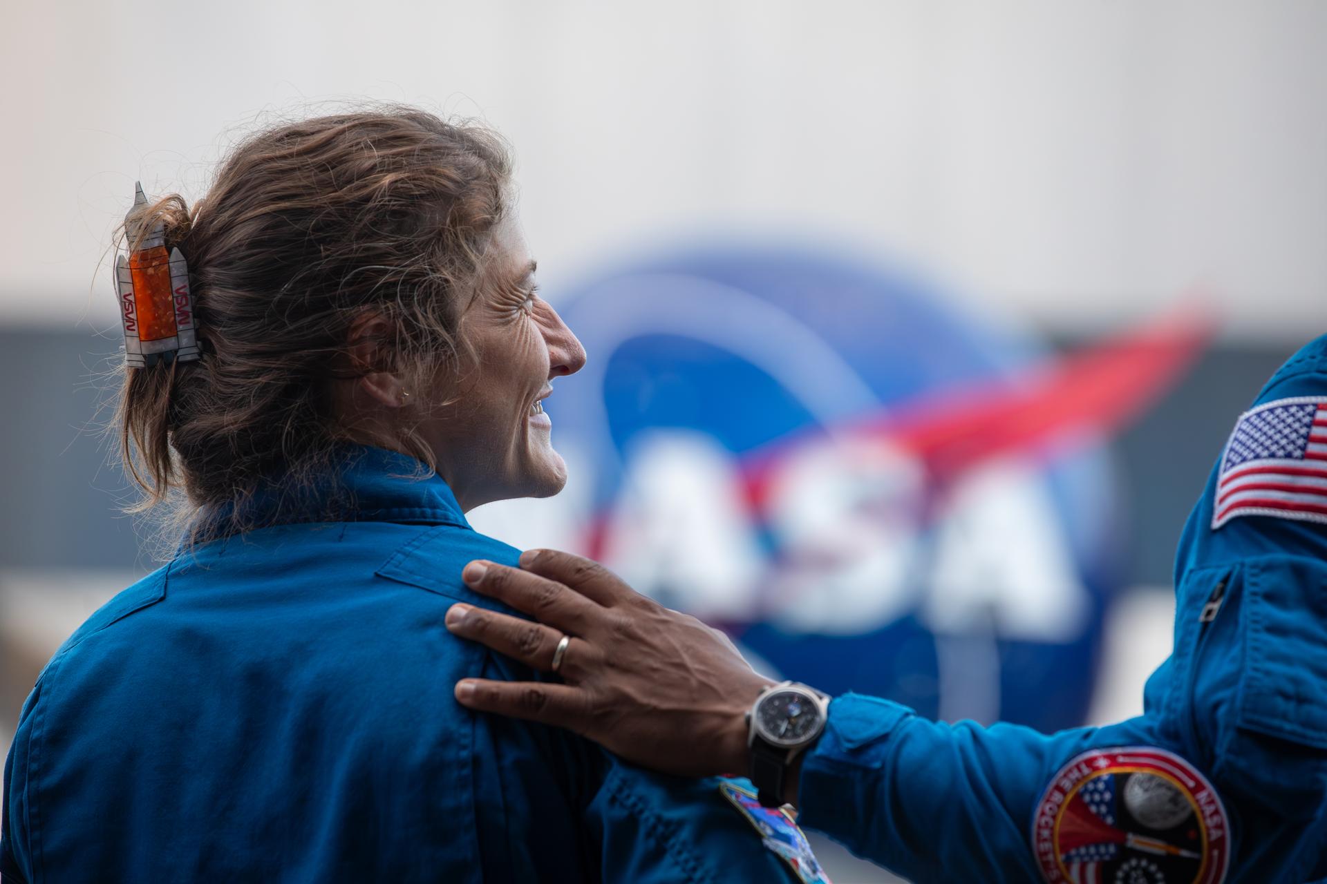 Artemis II NASA astronaut Christina Koch smiles as fellow Artemis II NASA astronaut Victor Glover speaks to agency employees at the Kennedy Space Center Visitor Complex in Florida on Tuesday, July 7, 2026. The Artemis II crew, NASA astronauts Koch, Glover, and Reid Wiseman, along with CSA (Canadian Space Agency) astronaut Jeremy Hansen, returned to NASA Kennedy for their first official visit since launch of Artemis II on Wednesday, April 1, 2026, to visit with the center’s workforce and tour facilities to view progress on Artemis III prelaunch processing.
