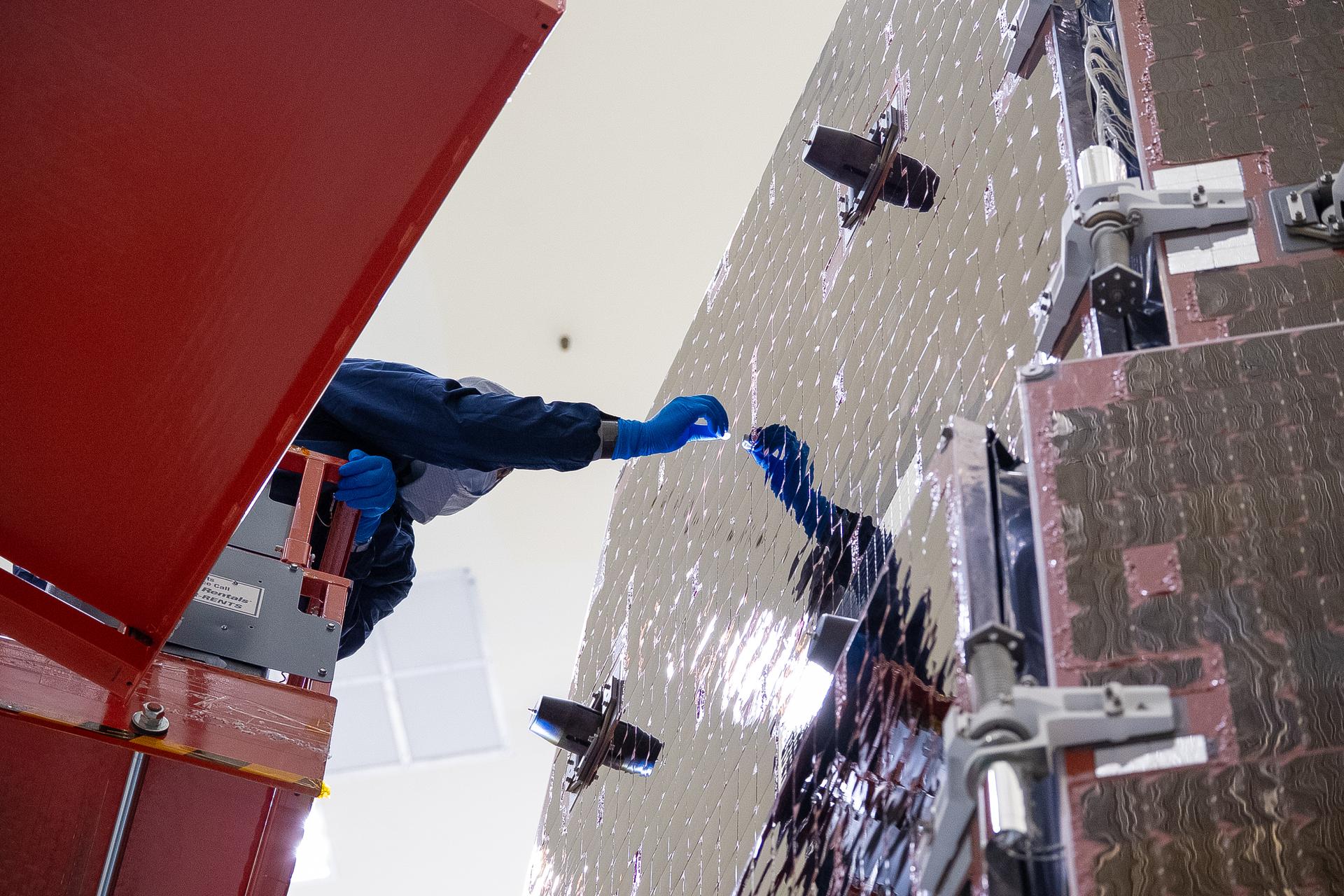 Technicians and engineers inside the Payload Hazardous Servicing Facility at NASA’s Kennedy Space Center in Florida clean and inspect the Solar Array Sun Shield (SASS) on the agency’s Nancy Grace Roman Space Telescope on Wednesday, July 8, 2026. The SASS is made up of six solar array panels, with the two center panels fixed while the four outer ones are deployed once in orbit. The Roman team will orient the SASS toward the Sun to provide power to the entire observatory and shade the telescope and instruments beneath. NASA designed this flagship mission to help astronomers explore dark matter, dark energy, and exoplanets.