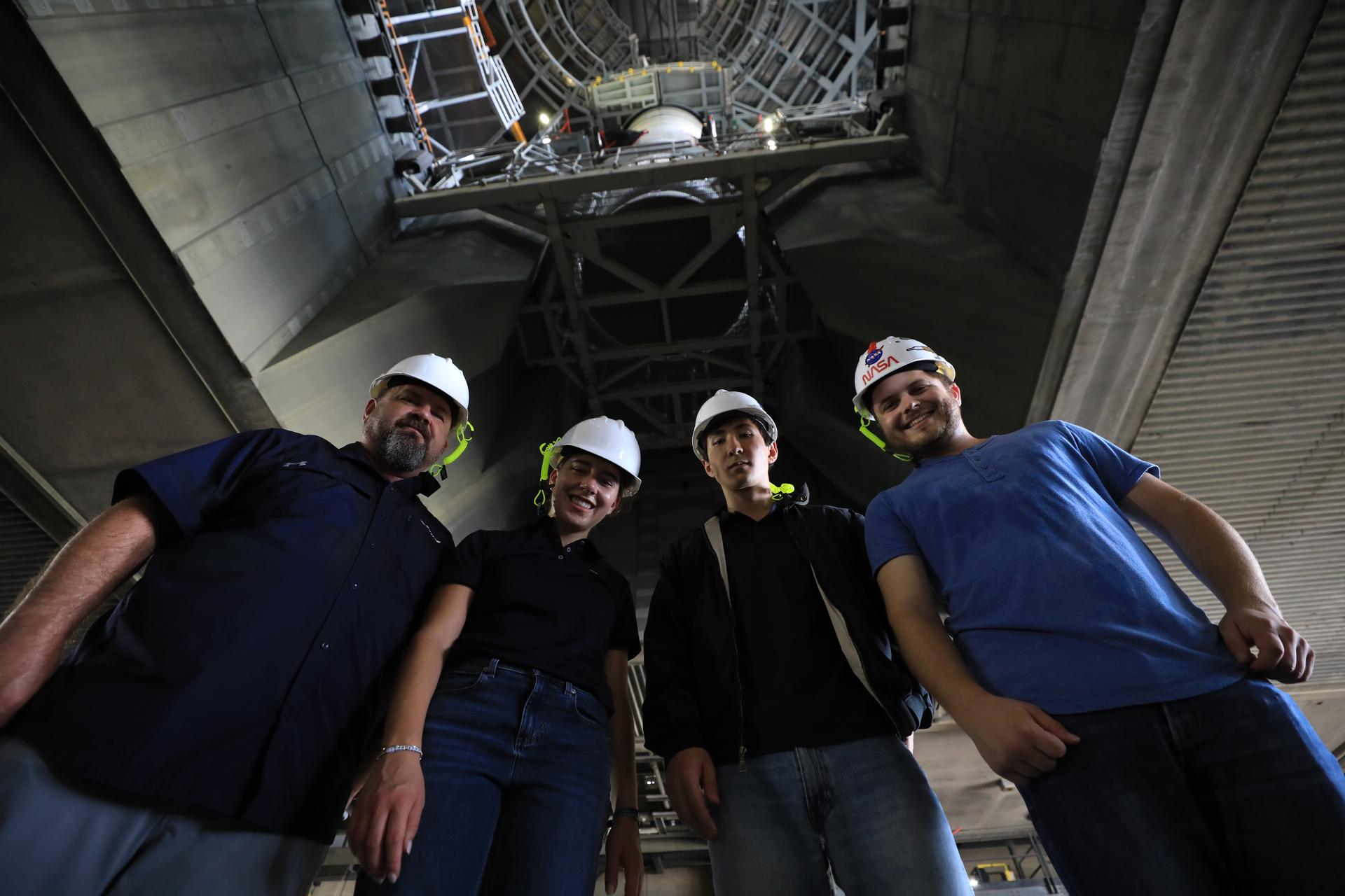 Boeing employees, from left to right, Adam Shaffer, Electrical Ground Systems equipment and technical lead engineer; Anna Fischer, Space Launch System electrical engineering intern; Ethan Minvielle, Space Launch System electrical engineering intern; and Joseph Colangelo, Space Launch System Test and evaluation engineering intern, pose for a photograph following left-hand aft assembly solid rocket booster segment for NASA’s Artemis III SLS (Space Launch System) was secured to the mobile launcher at the agency’s Vehicle Assembly Building at NASA Kennedy on Thursday, July 9, 2026. The twin boosters, manufactured by Northrop Grumman in Utah, will provide more than 75 percent of the SLS rocket’s total thrust at launch. The Artemis III mission will launch crew in the Orion spacecraft on top of the SLS rocket to test rendezvous and docking capabilities between Orion and commercial spacecraft needed to land astronauts on the Moon.