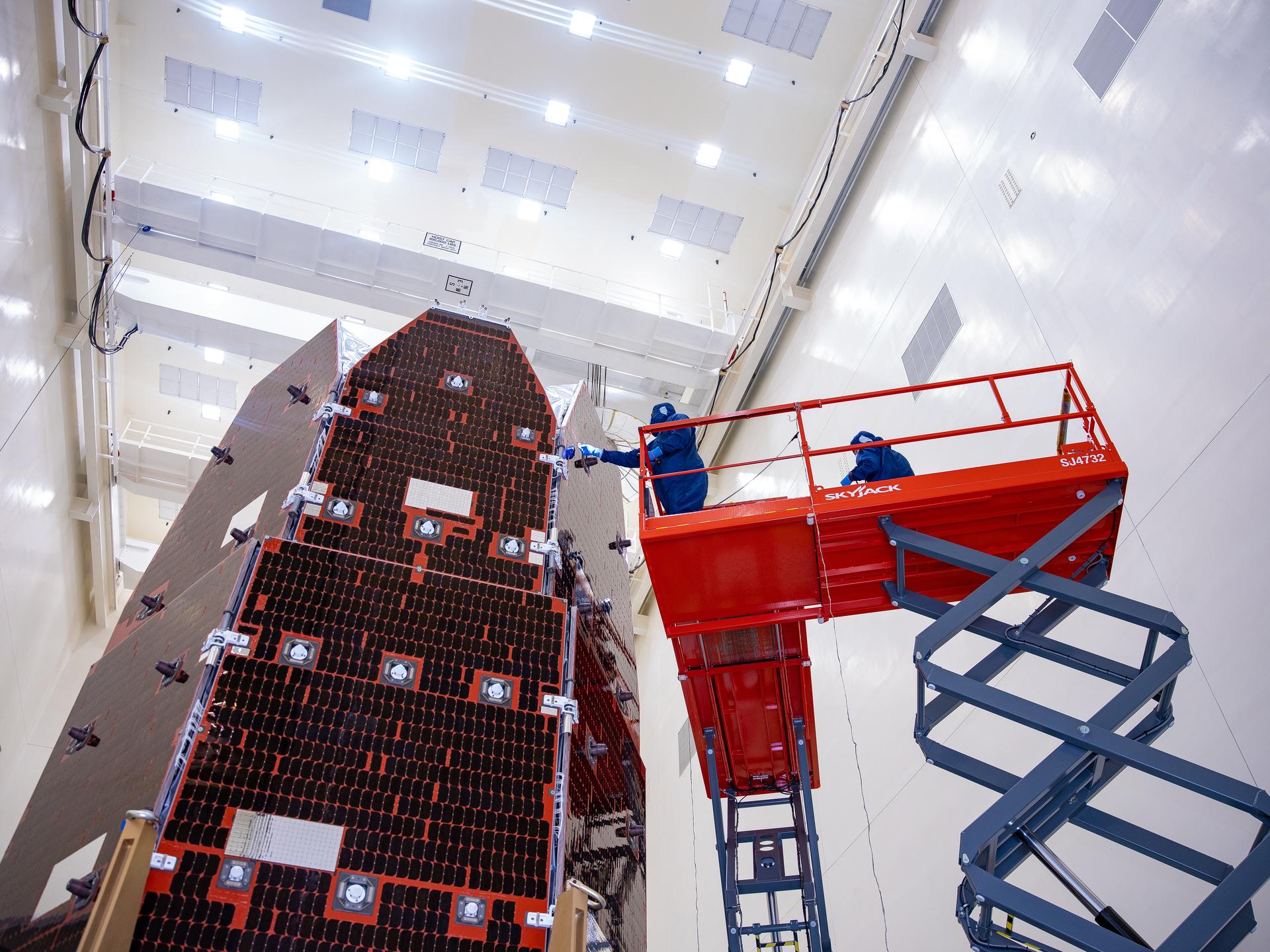 Technicians and engineers inside the Payload Hazardous Servicing Facility at NASA’s Kennedy Space Center in Florida clean and inspect the Solar Array Sun Shield (SASS) on the agency’s Nancy Grace Roman Space Telescope on Thursday, July 9, 2026. The SASS is made up of six solar array panels, with the two center panels fixed while the four outer ones are deployed once in orbit. The Roman team will orient the SASS toward the Sun to provide power to the entire observatory and shade the telescope and instruments beneath. NASA designed this flagship mission to help astronomers explore dark matter, dark energy, and exoplanets.