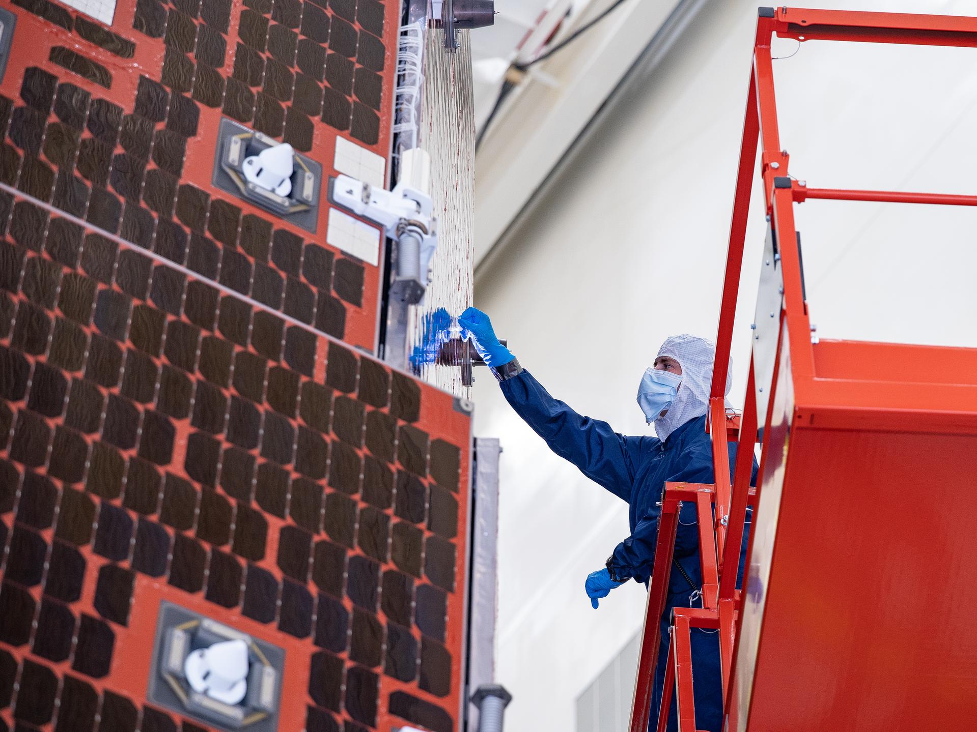Technicians and engineers inside the Payload Hazardous Servicing Facility at NASA’s Kennedy Space Center in Florida clean and inspect the Solar Array Sun Shield (SASS) on the agency’s Nancy Grace Roman Space Telescope on Thursday, July 9, 2026. The SASS is made up of six solar array panels, with the two center panels fixed while the four outer ones are deployed once in orbit. The Roman team will orient the SASS toward the Sun to provide power to the entire observatory and shade the telescope and instruments beneath. NASA designed this flagship mission to help astronomers explore dark matter, dark energy, and exoplanets.