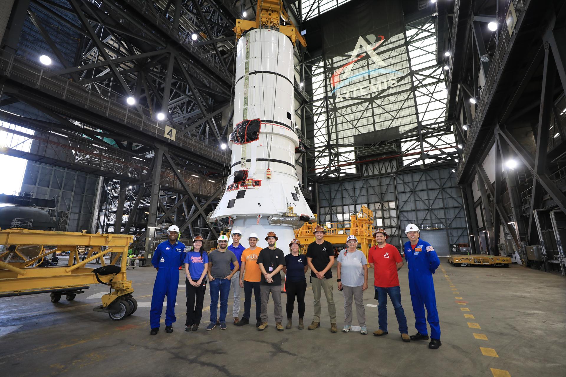 Artemis III crew members, NASA astronauts Randy Bresnick (far right) and Andre Douglas (far left), pose with teams from NASA’s Exploration Ground Systems in front of the right-hand aft assembly solid rocket booster segment of the Artemis III SLS (Space Launch System) rocket inside the Vehicle Assembly Building at the agency’s Kennedy Space Center in Florida on Friday, July 10, 2026. The astronauts met with NASA’s teams and got a close look at the work underway for their upcoming mission. Bresnick, Douglas, NASA astronaut Frank Rubio, and ESA (European Space Agency) astronaut Luca Parmitano will launch on the Artemis III mission to conduct critical rendezvous and docking tests with lunar lander systems in low Earth orbit, advancing the capabilities needed before astronauts return to the lunar surface on Artemis IV.