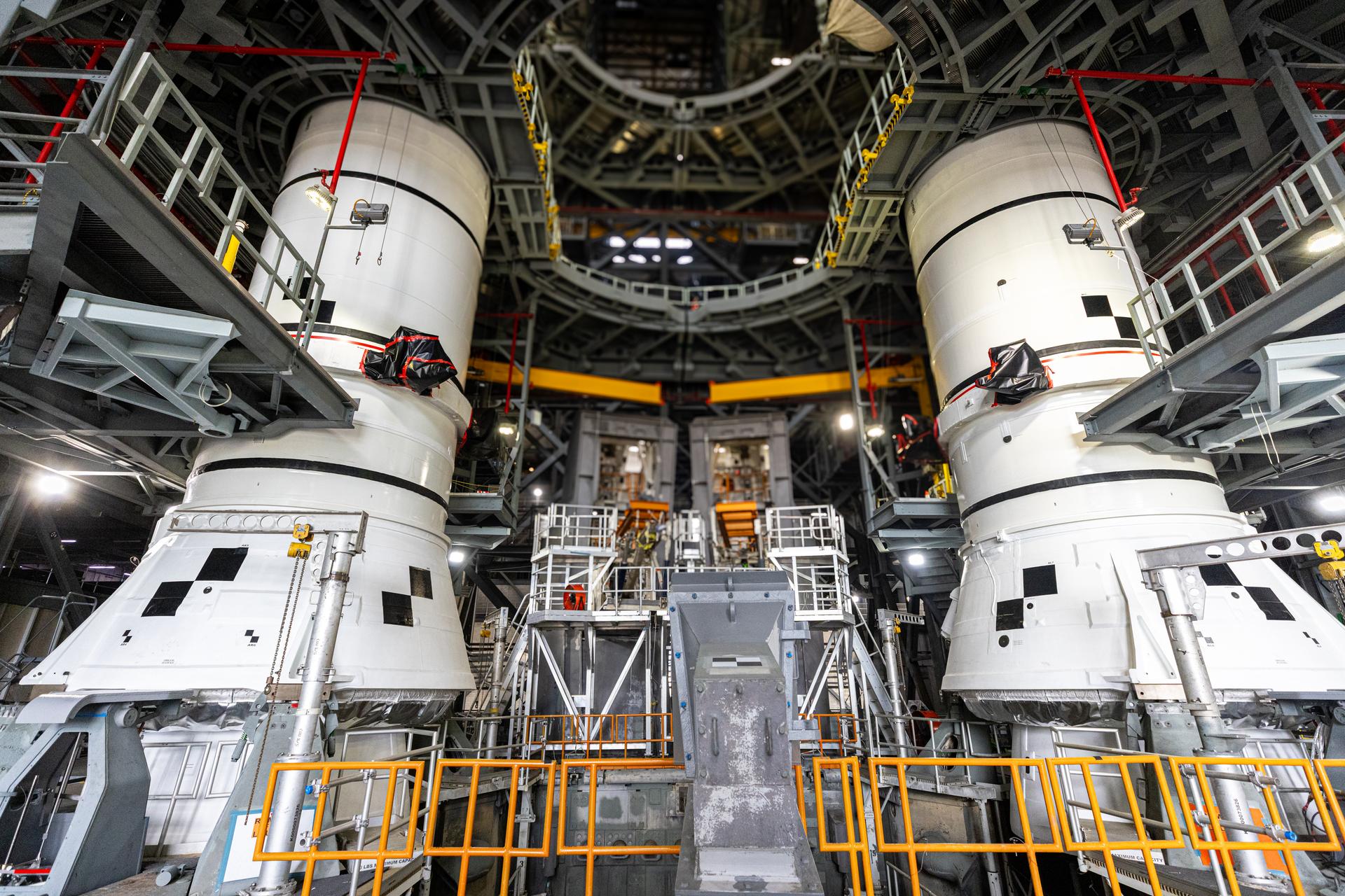 The left-hand and right-hand aft assembly solid rocket booster segments for NASA’s Artemis III SLS (Space Launch System) rocket are secured to the mobile launcher at the agency’s Vehicle Assembly Building at NASA’s Kennedy Space Center in Florida on Saturday, July 11, 2026. The twin boosters, manufactured by Northrop Grumman in Utah, will provide more than 75 percent of the SLS rocket’s total thrust at launch. The Artemis III mission will launch astronauts in the Orion spacecraft on top of the SLS rocket to test rendezvous and docking capabilities between Orion and commercial spacecraft needed to land astronauts on the Moon.