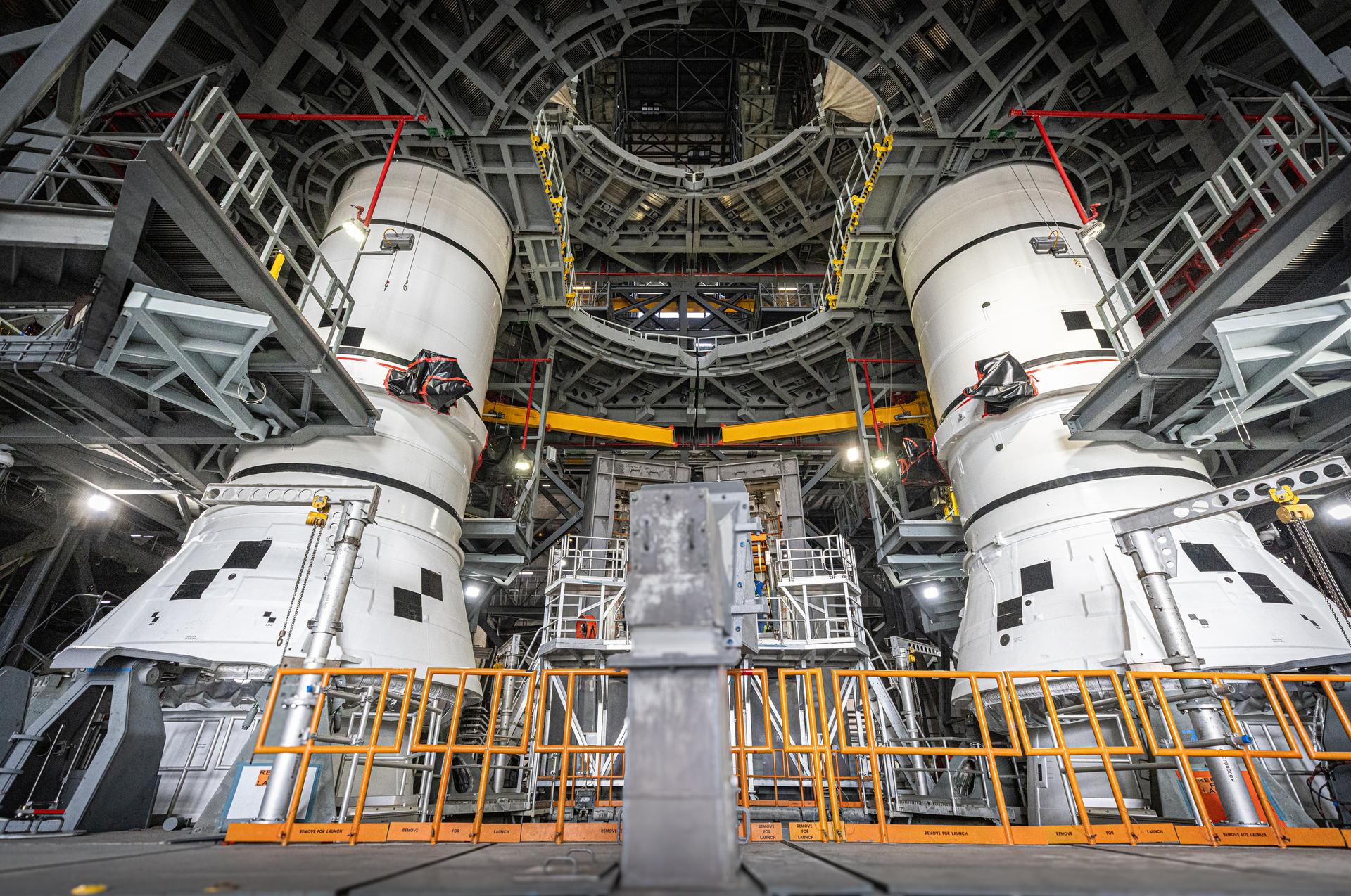 The left-hand and right-hand aft assembly solid rocket booster segments for NASA’s Artemis III SLS (Space Launch System) rocket are secured to the mobile launcher at the agency’s Vehicle Assembly Building at NASA’s Kennedy Space Center in Florida on Saturday, July 11, 2026. The twin boosters, manufactured by Northrop Grumman in Utah, will provide more than 75 percent of the SLS rocket’s total thrust at launch. The Artemis III mission will launch astronauts in the Orion spacecraft on top of the SLS rocket to test rendezvous and docking capabilities between Orion and commercial spacecraft needed to land astronauts on the Moon.