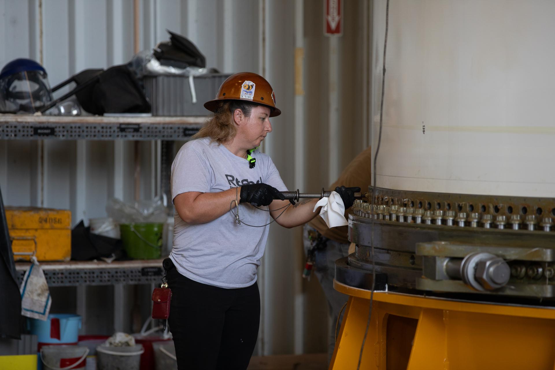 Tia Harbour, engineering technician, COMET (Consolidated Operations, Management, Engineering, and Test) employee secures the right-hand forward center assembly solid rocket booster segment for the Artemis III SLS (Space Launch System) rocket onto a work stand inside the Rotation, Processing, and Surge Facility at NASA’s Kennedy Space Center in Florida on Tuesday, July 14, 2026. The twin boosters, manufactured by Northrop Grumman in Utah, will provide more than 75 percent of the SLS rocket’s total thrust at launch. The Artemis III mission will launch astronauts in the Orion spacecraft on top of the SLS rocket to test rendezvous and docking capabilities between Orion and commercial spacecraft needed to land astronauts on the Moon.