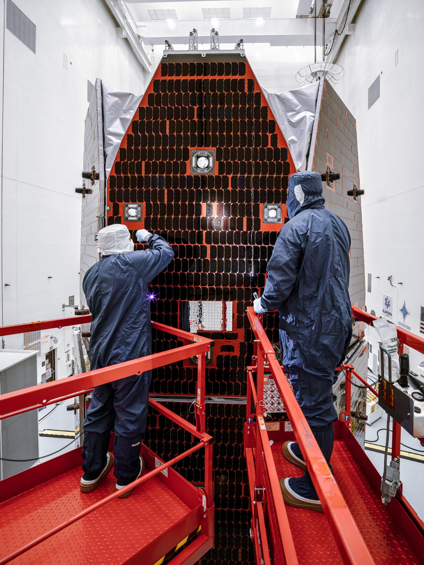 Technicians and engineers inside the Payload Hazardous Servicing Facility at NASA’s Kennedy Space Center in Florida clean and inspect the Solar Array Sun Shield (SASS) on the agency’s Nancy Grace Roman Space Telescope on Tuesday, July 14, 2026. The SASS is made up of six solar array panels, with the two center panels fixed while the four outer ones are deployed once in orbit. The Roman team will orient the SASS toward the Sun to provide power to the entire observatory and shade the telescope and instruments beneath. NASA designed this flagship mission to help astronomers explore dark matter, dark energy, and exoplanets.