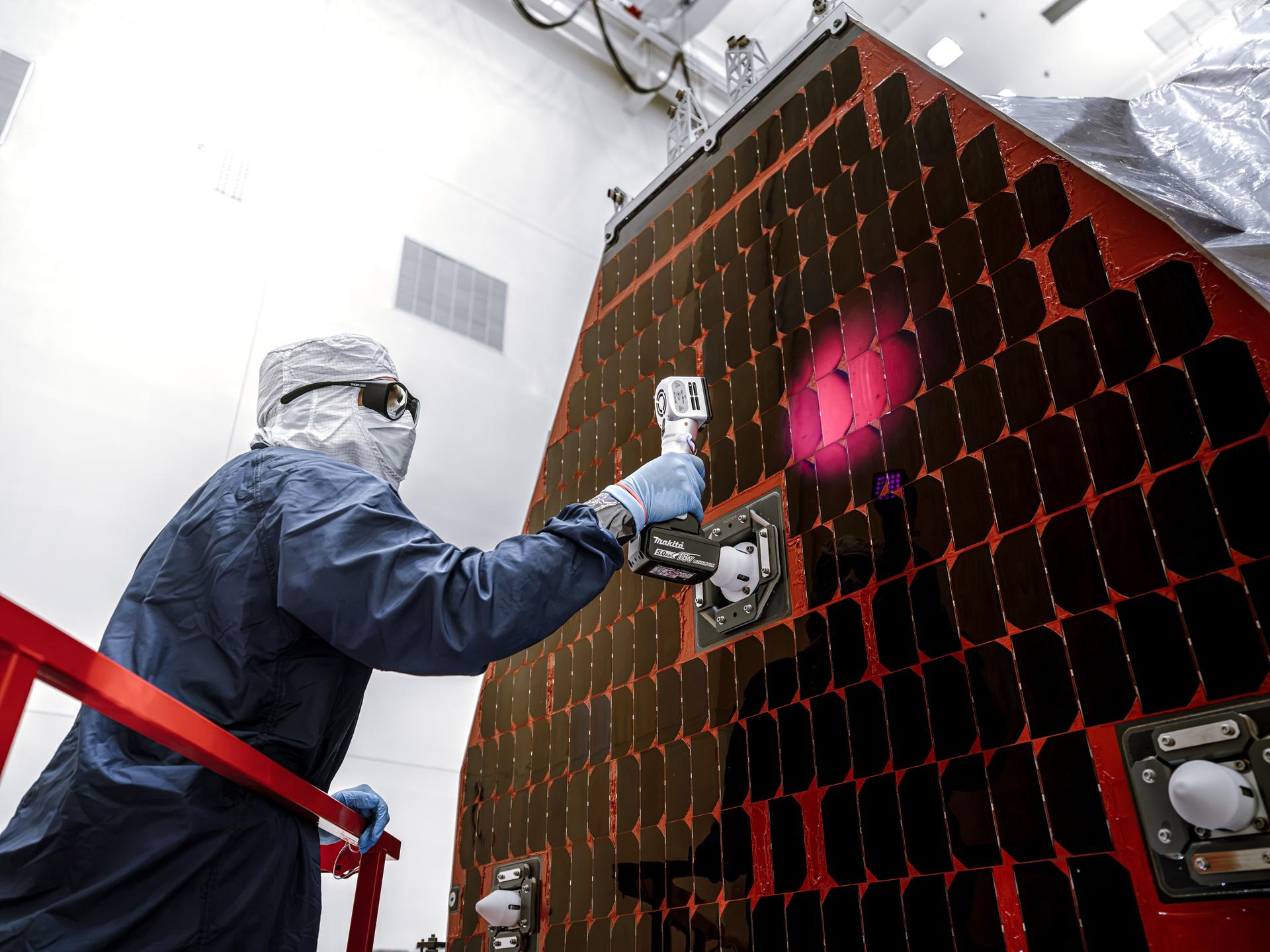Technicians and engineers inside the Payload Hazardous Servicing Facility at NASA’s Kennedy Space Center in Florida clean and inspect the Solar Array Sun Shield (SASS) on the agency’s Nancy Grace Roman Space Telescope on Tuesday, July 14, 2026. The SASS is made up of six solar array panels, with the two center panels fixed while the four outer ones are deployed once in orbit. The Roman team will orient the SASS toward the Sun to provide power to the entire observatory and shade the telescope and instruments beneath. NASA designed this flagship mission to help astronomers explore dark matter, dark energy, and exoplanets.
