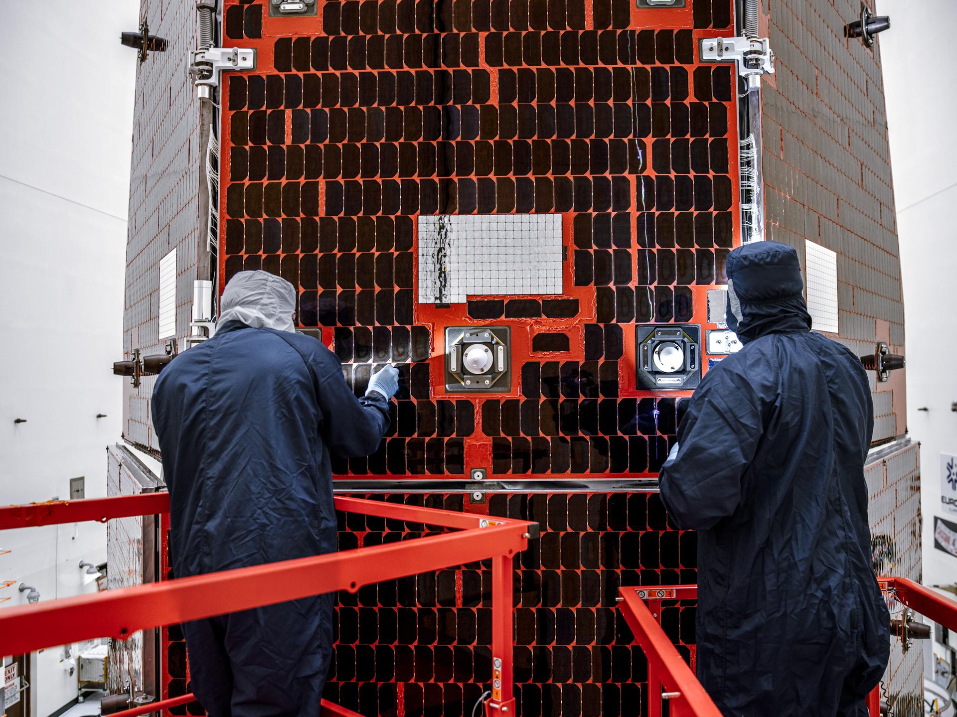 Technicians and engineers inside the Payload Hazardous Servicing Facility at NASA’s Kennedy Space Center in Florida clean and inspect the Solar Array Sun Shield (SASS) on the agency’s Nancy Grace Roman Space Telescope on Tuesday, July 14, 2026. The SASS is made up of six solar array panels, with the two center panels fixed while the four outer ones are deployed once in orbit. The Roman team will orient the SASS toward the Sun to provide power to the entire observatory and shade the telescope and instruments beneath. NASA designed this flagship mission to help astronomers explore dark matter, dark energy, and exoplanets.