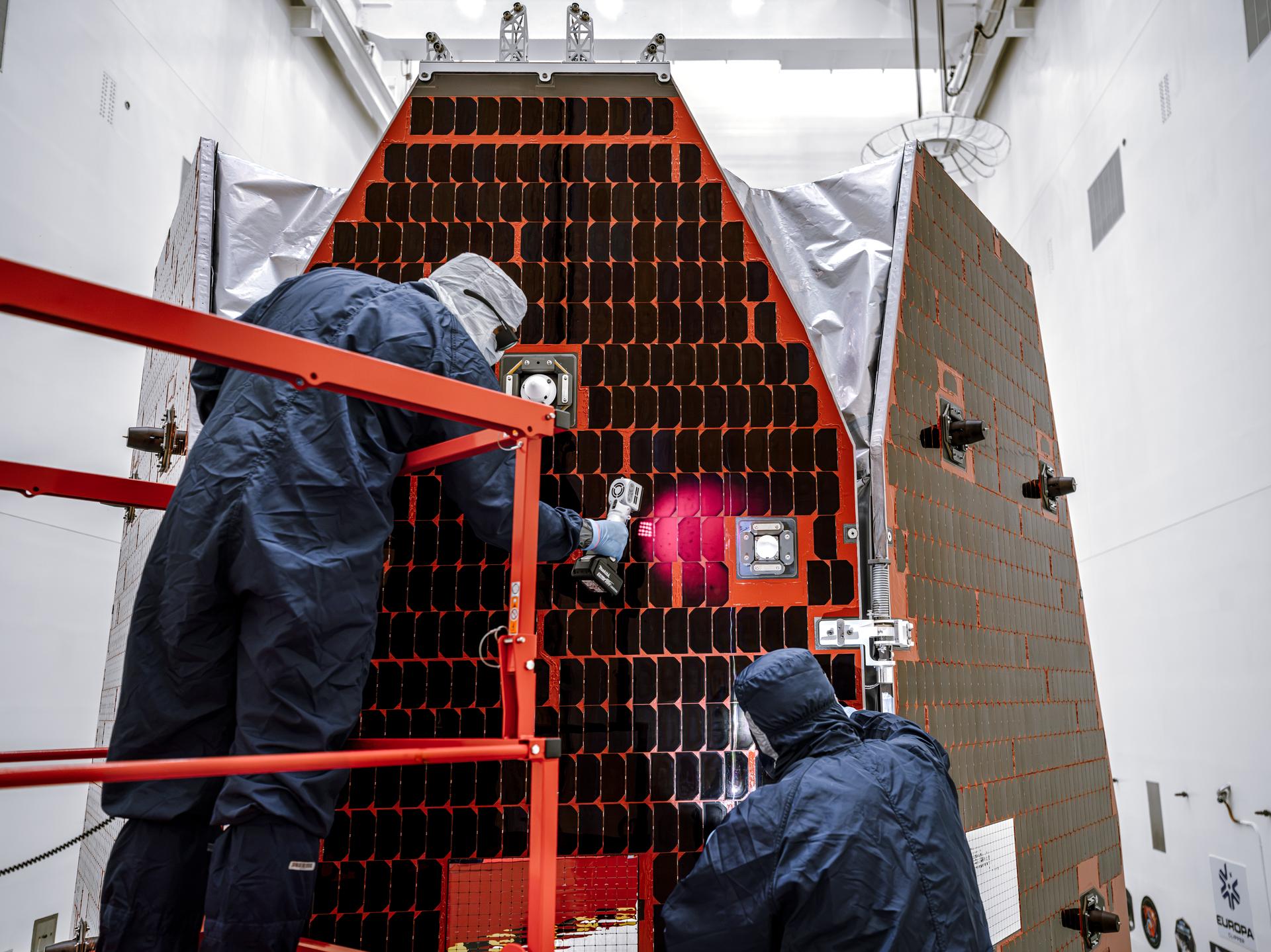 Technicians and engineers inside the Payload Hazardous Servicing Facility at NASA’s Kennedy Space Center in Florida clean and inspect the Solar Array Sun Shield (SASS) on the agency’s Nancy Grace Roman Space Telescope on Tuesday, July 14, 2026. The SASS is made up of six solar array panels, with the two center panels fixed while the four outer ones are deployed once in orbit. The Roman team will orient the SASS toward the Sun to provide power to the entire observatory and shade the telescope and instruments beneath. NASA designed this flagship mission to help astronomers explore dark matter, dark energy, and exoplanets.