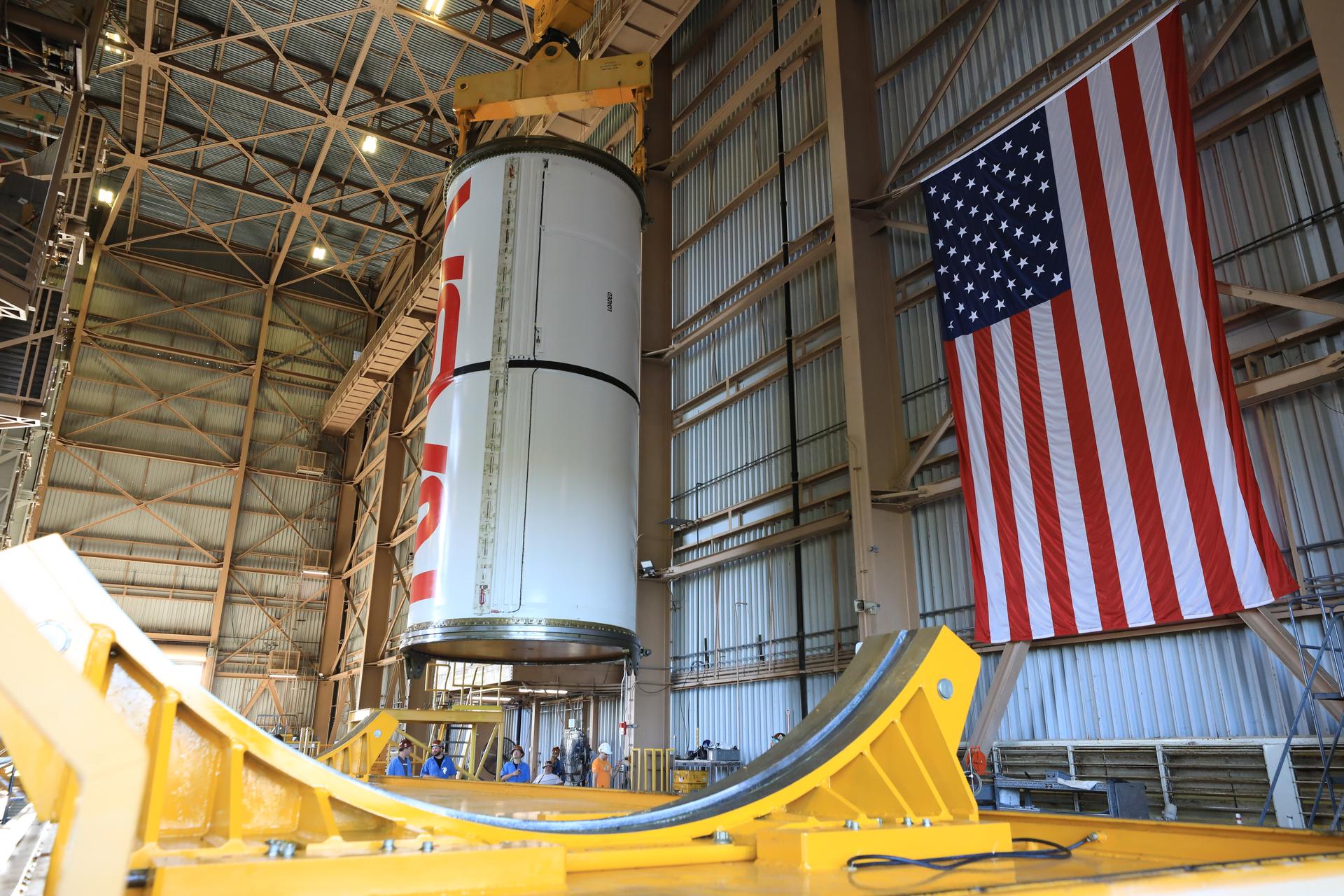 Technicians with NASA’s Exploration Ground Systems Program lift the right center center solid rocket booster, containing the NASA “worm” insignia, for the agency’s Artemis III SLS (Space Launch System) rocket onto the work stand ahead of inspection inside the Rotation, Processing and Surge Facility at the agency’s Kennedy Space Center in Florida on Wednesday, July 22, 2026. The SLS rocket’s twin boosters, manufactured by Northrop Grumman in Utah, will provide more than 75 percent of the SLS rocket’s total thrust at launch. The Artemis III mission will launch crew in the Orion spacecraft on top of the SLS rocket to test rendezvous and docking capabilities between Orion and commercial spacecraft needed to land astronauts on the Moon.