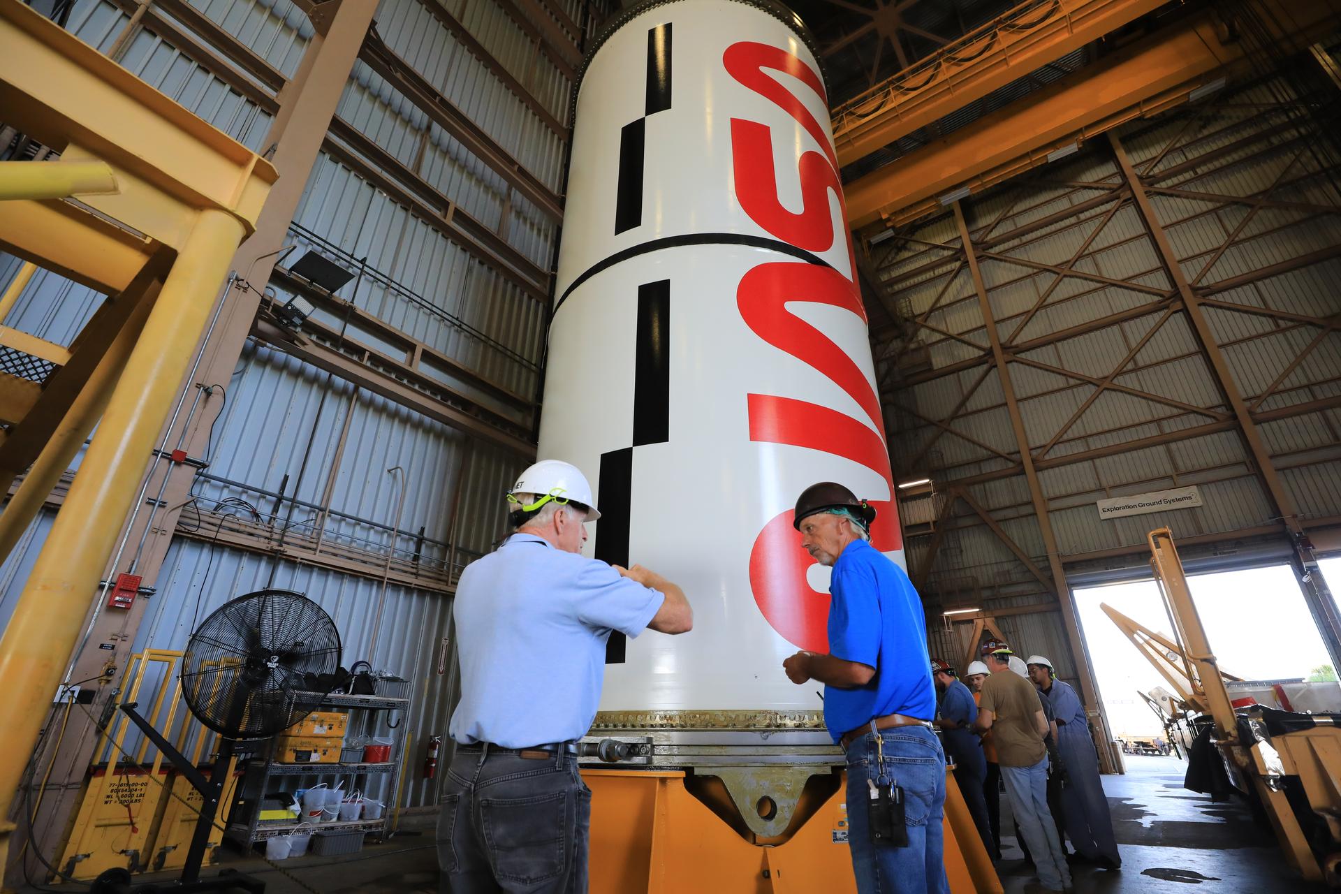 Technicians Wade Parris and Lon Coffin with Amentum Services, Inc. for NASA’s Exploration Ground Systems Program inspect the right center center solid rocket booster segment for the agency’s Artemis III SLS (Space Launch System) rocket inside the Rotation, Processing and Surge Facility at the agency’s Kennedy Space Center in Florida on Thursday, July 23, 2026. The SLS rocket’s twin boosters, manufactured by Northrop Grumman in Utah, will provide more than 75 percent of the SLS rocket’s total thrust at launch. The Artemis III mission will launch crew in the Orion spacecraft on top of the SLS rocket to test rendezvous and docking capabilities between Orion and commercial spacecraft needed to land astronauts on the Moon.