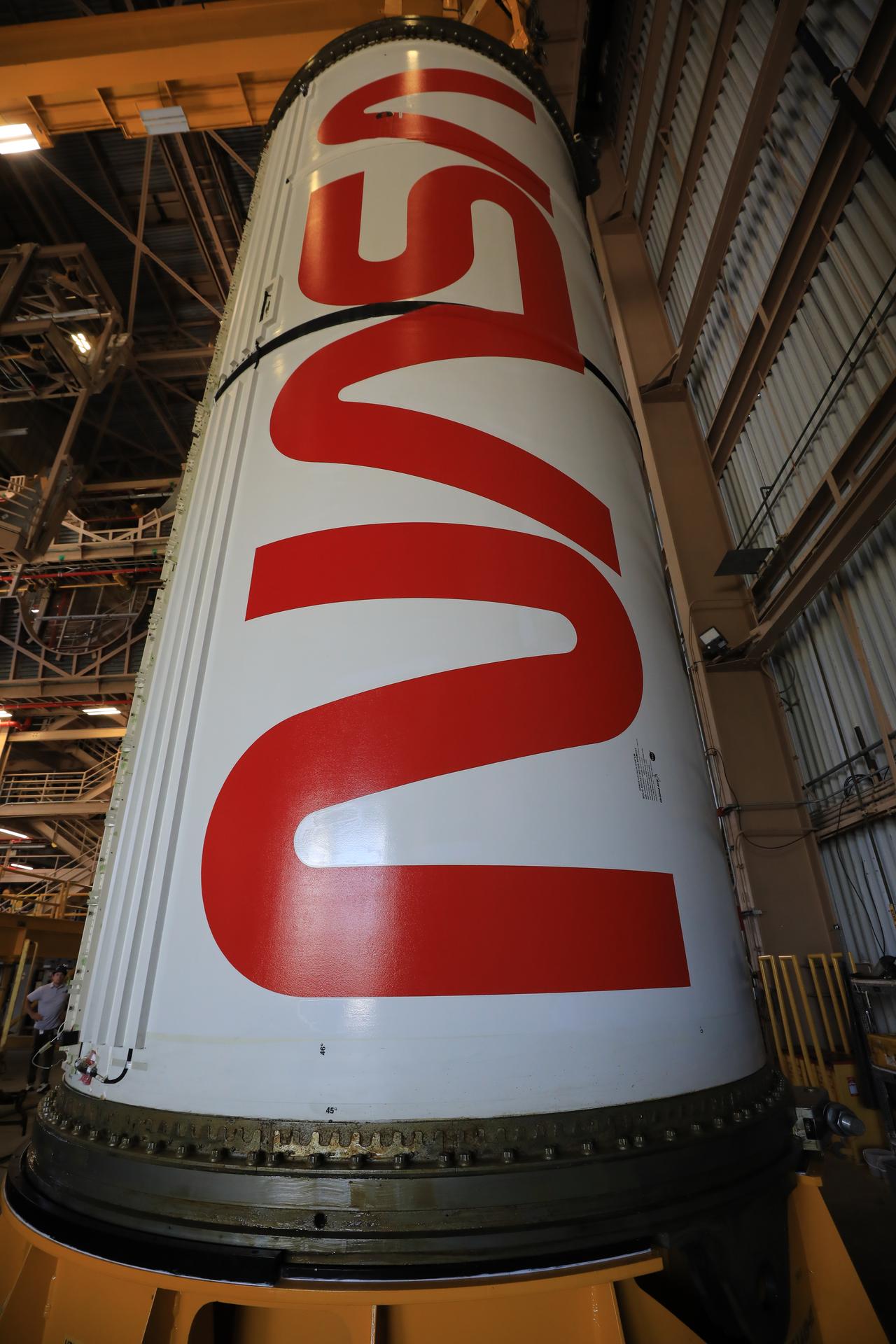 The right center center solid rocket booster segment, containing the NASA “worm” insignia, for the agency’s Artemis III SLS (Space Launch System) rocket undergoes processing inside the Rotation, Processing and Surge Facility at the agency’s Kennedy Space Center in Florida on Thursday, July 23, 2026. The SLS rocket’s twin boosters, manufactured by Northrop Grumman in Utah, will provide more than 75 percent of the SLS rocket’s total thrust at launch. The Artemis III mission will launch crew in the Orion spacecraft on top of the SLS rocket to test rendezvous and docking capabilities between Orion and commercial spacecraft needed to land astronauts on the Moon.