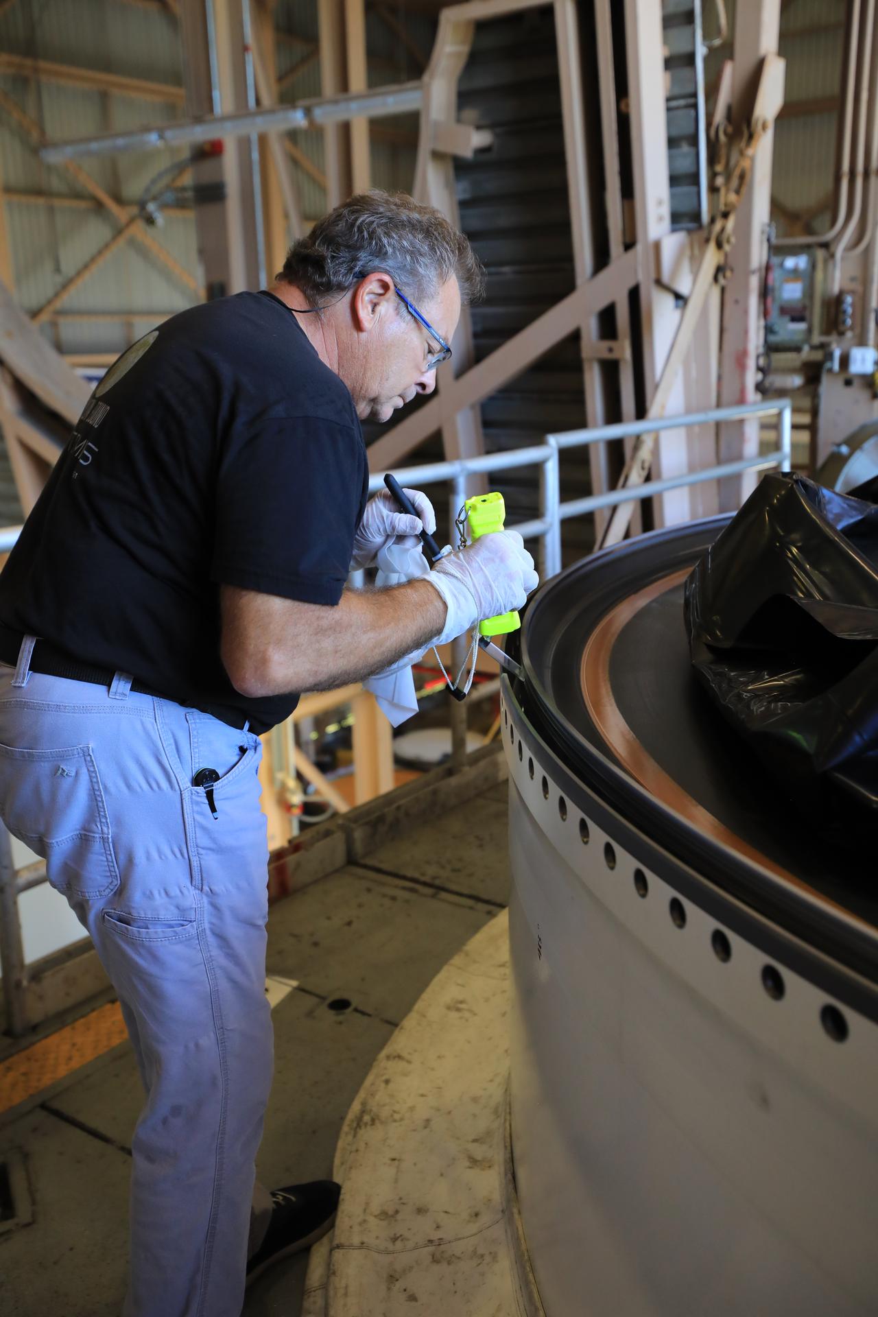 Kevin Unger, Quality Insurance Inspector with NASA’s Exploration Ground Systems Program, inspects the left center center solid rocket booster segment for the agency’s Artemis III SLS (Space Launch System) rocket inside the Rotation, Processing and Surge Facility at the agency’s Kennedy Space Center in Florida on Thursday, July 23, 2026. The SLS rocket’s twin boosters, manufactured by Northrop Grumman in Utah, will provide more than 75 percent of the SLS rocket’s total thrust at launch. The Artemis III mission will launch crew in the Orion spacecraft on top of the SLS rocket to test rendezvous and docking capabilities between Orion and commercial spacecraft needed to land astronauts on the Moon.
