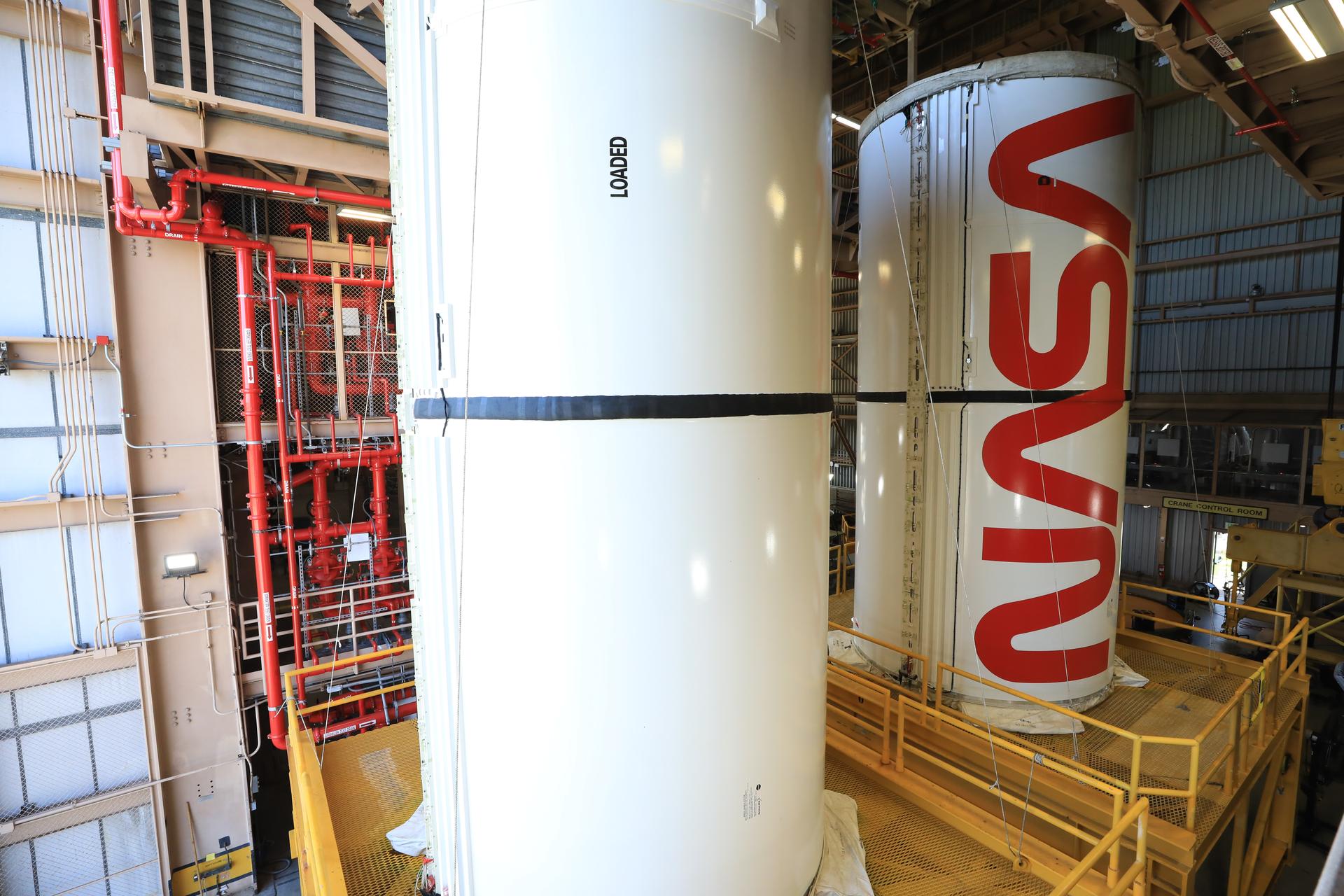 The right center center solid rocket booster segment, containing the NASA “worm” insignia, and the left center center solid rocket booster segment for the agency’s Artemis III SLS (Space Launch System) rocket undergo processing inside the Rotation, Processing and Surge Facility at the agency’s Kennedy Space Center in Florida on Friday, July 24, 2026. The SLS rocket’s twin boosters, manufactured by Northrop Grumman in Utah, will provide more than 75 percent of the SLS rocket’s total thrust at launch. The Artemis III mission will launch crew in the Orion spacecraft on top of the SLS rocket to test rendezvous and docking capabilities between Orion and commercial spacecraft needed to land astronauts on the Moon.