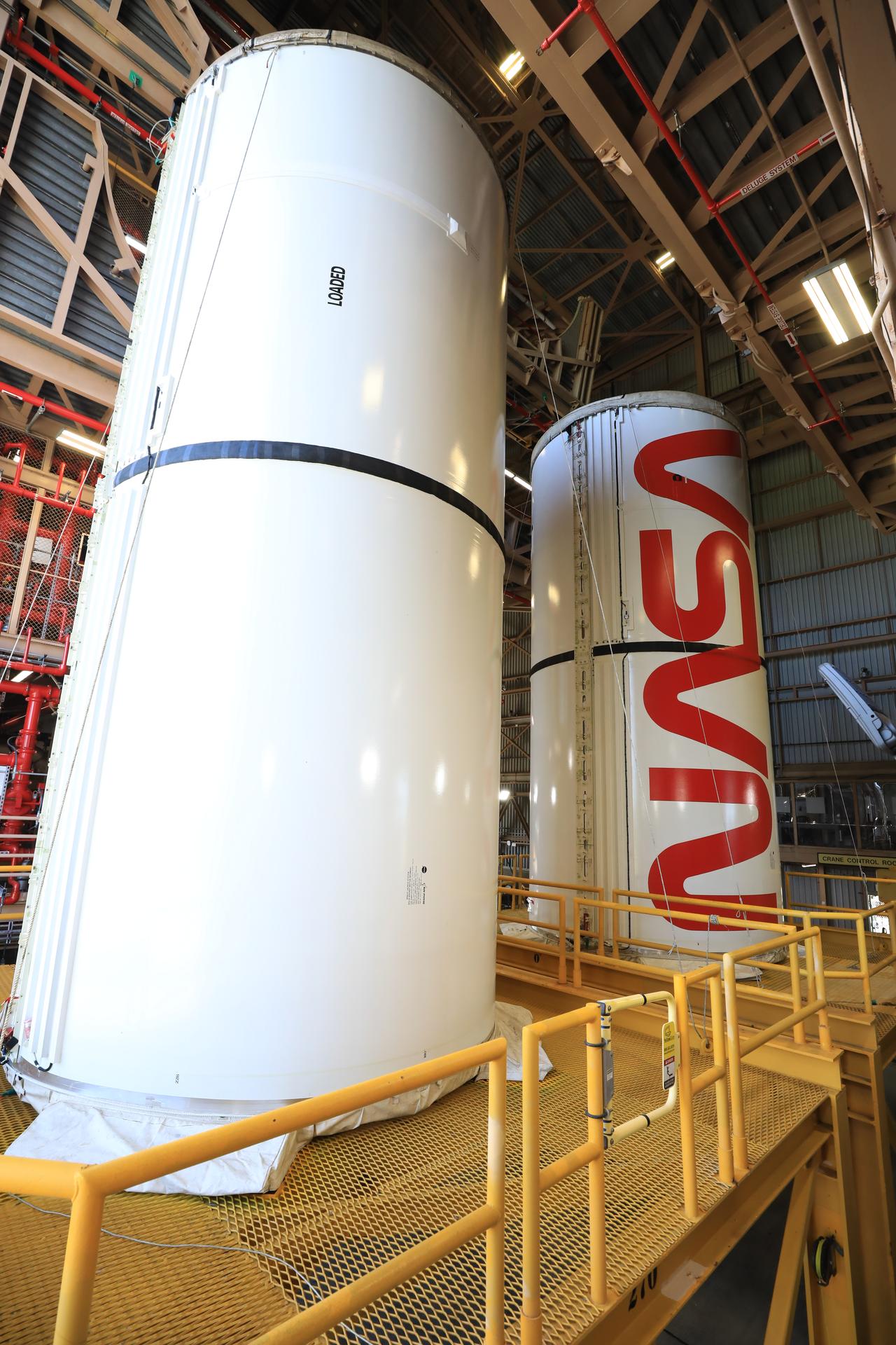 The right center center solid rocket booster segment, containing the NASA “worm” insignia, and the left center center solid rocket booster segment for the agency’s Artemis III SLS (Space Launch System) rocket undergo processing inside the Rotation, Processing and Surge Facility at the agency’s Kennedy Space Center in Florida on Friday, July 24, 2026. The SLS rocket’s twin boosters, manufactured by Northrop Grumman in Utah, will provide more than 75 percent of the SLS rocket’s total thrust at launch. The Artemis III mission will launch crew in the Orion spacecraft on top of the SLS rocket to test rendezvous and docking capabilities between Orion and commercial spacecraft needed to land astronauts on the Moon.