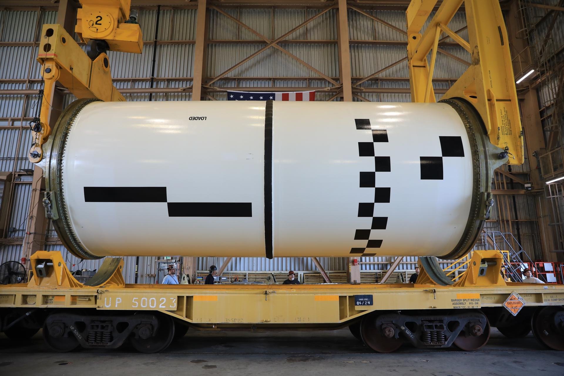 Technicians use a massive crane to rotate and lift the right-hand aft center assembly solid rocket booster segment for NASA’s Artemis III SLS (Space Launch System) rocket onto a work stand at the Rotation, Processing, and Surge Facility at the agency’s Kennedy Space Center in Florida on Wednesday, July 29, 2026. The twin boosters, comprising five segments each manufactured by Northrop Grumman in Utah, will provide more than 75 percent of the SLS rocket’s total thrust at launch. The Artemis III mission will launch crew in the Orion spacecraft on top of the SLS rocket to test rendezvous and docking capabilities between Orion and commercial spacecraft needed to land astronauts on the Moon.