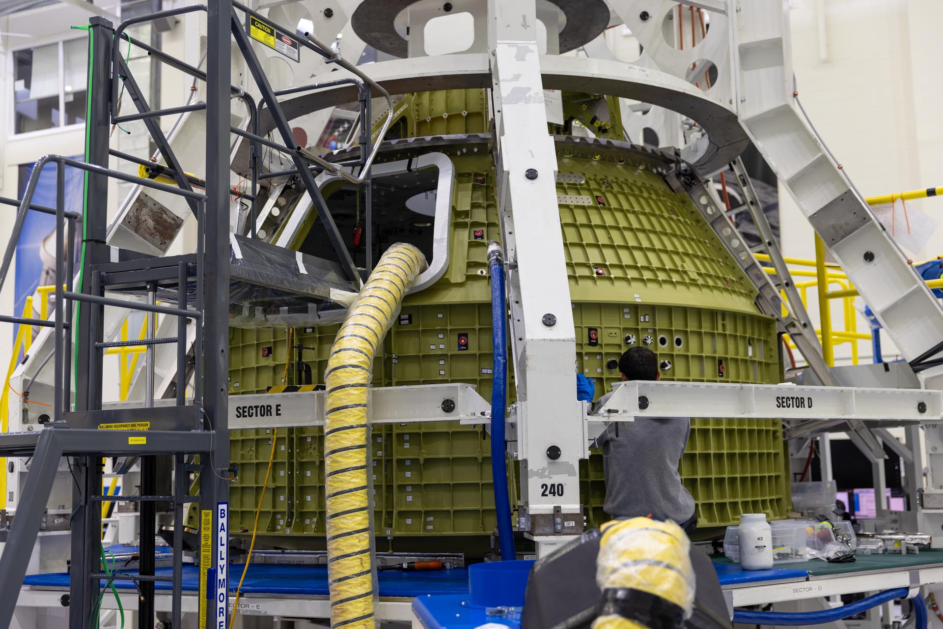 A photographer captures the Artemis V Orion crew module on Friday, July 31, 2026, inside the Neil A. Armstrong Operations and Checkout Building at NASA’s Kennedy Space Center in Florida. There are currently several pieces of hardware from Artemis III, IV, and V undergoing processing at the same time inside the facility. Using the standard SLS (Space Launch System) rocket configuration, NASA expects to launch this lunar surface mission by late 2028, with subsequent missions planned roughly once per year.
