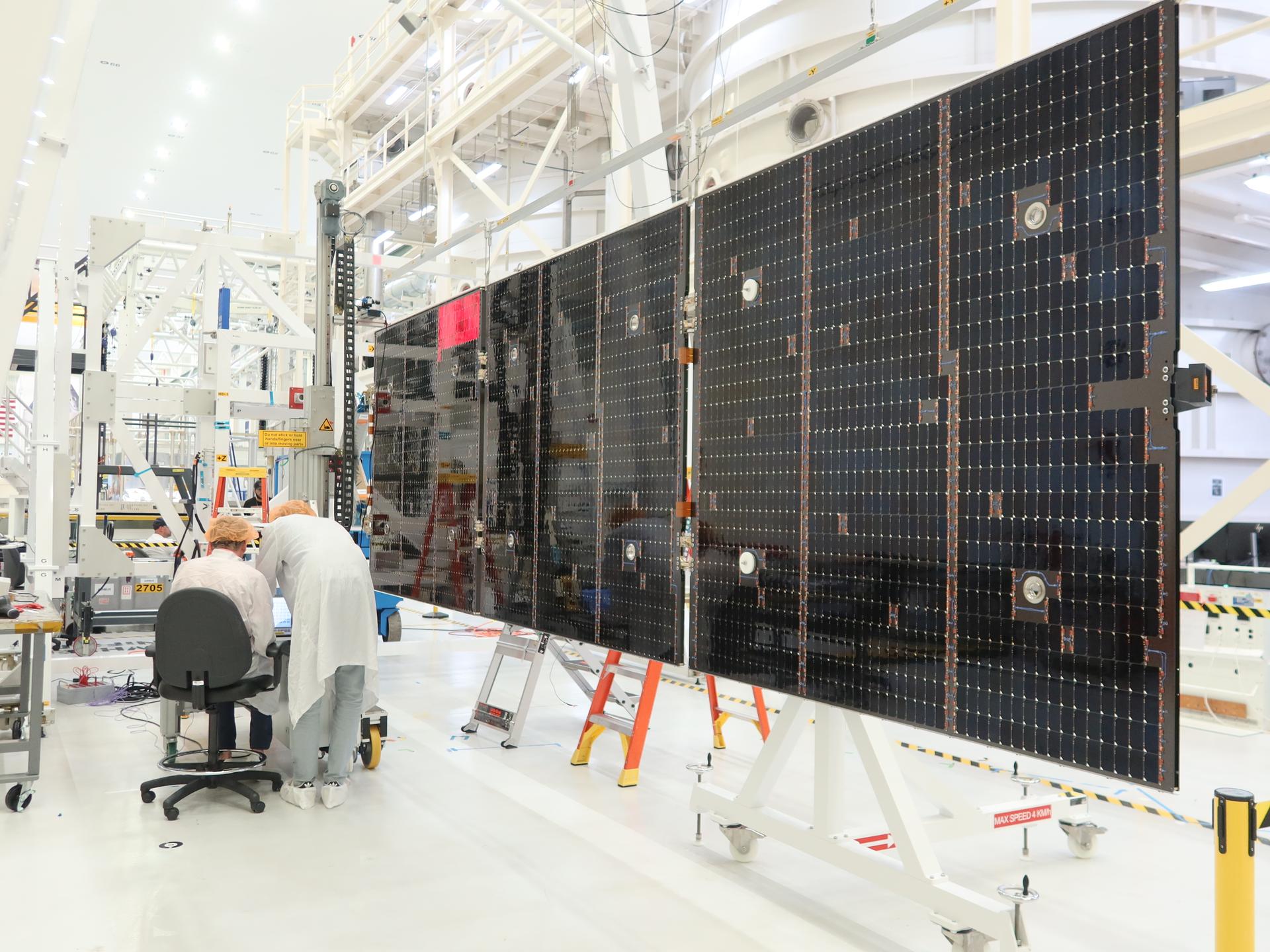 Technicians extend and inspect one of the solar array wing panels that will attach the Orion service module for Artemis III inside the Neil A. Armstrong Operations and Checkout Building high bay at NASA’s Kennedy Space Center in Florida on Tuesday, Aug. 18, 2026. Each solar array panel, provided by the European Space Agency and built by Airbus, generates 11 kilowatts of power and spans about 63 feet to supply Orion’s power, propulsion, air, and water through low Earth Orbit.