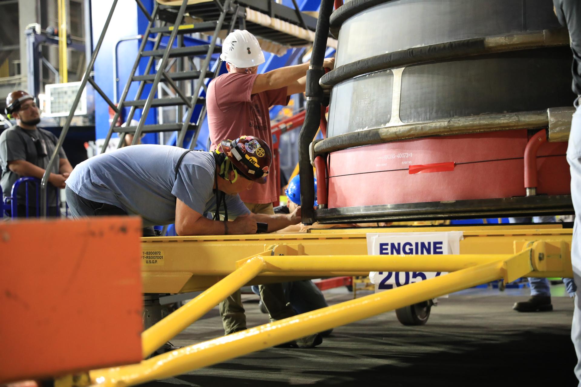 Technicians prepare the #2 RS-25 SLS (Space Launch System) rocket engine for transfer onto a work stand ahead of integration with the Artemis III core stage rocket on Tuesday, Aug. 25, 2026, inside the Vehicle Assembly Building at NASA’s Kennedy Space Center in Florida. During Artemis III, the four RS‑25 engines will launch the Orion spacecraft and its crew of four into low Earth orbit, generating more than two million pounds of thrust at liftoff. 
