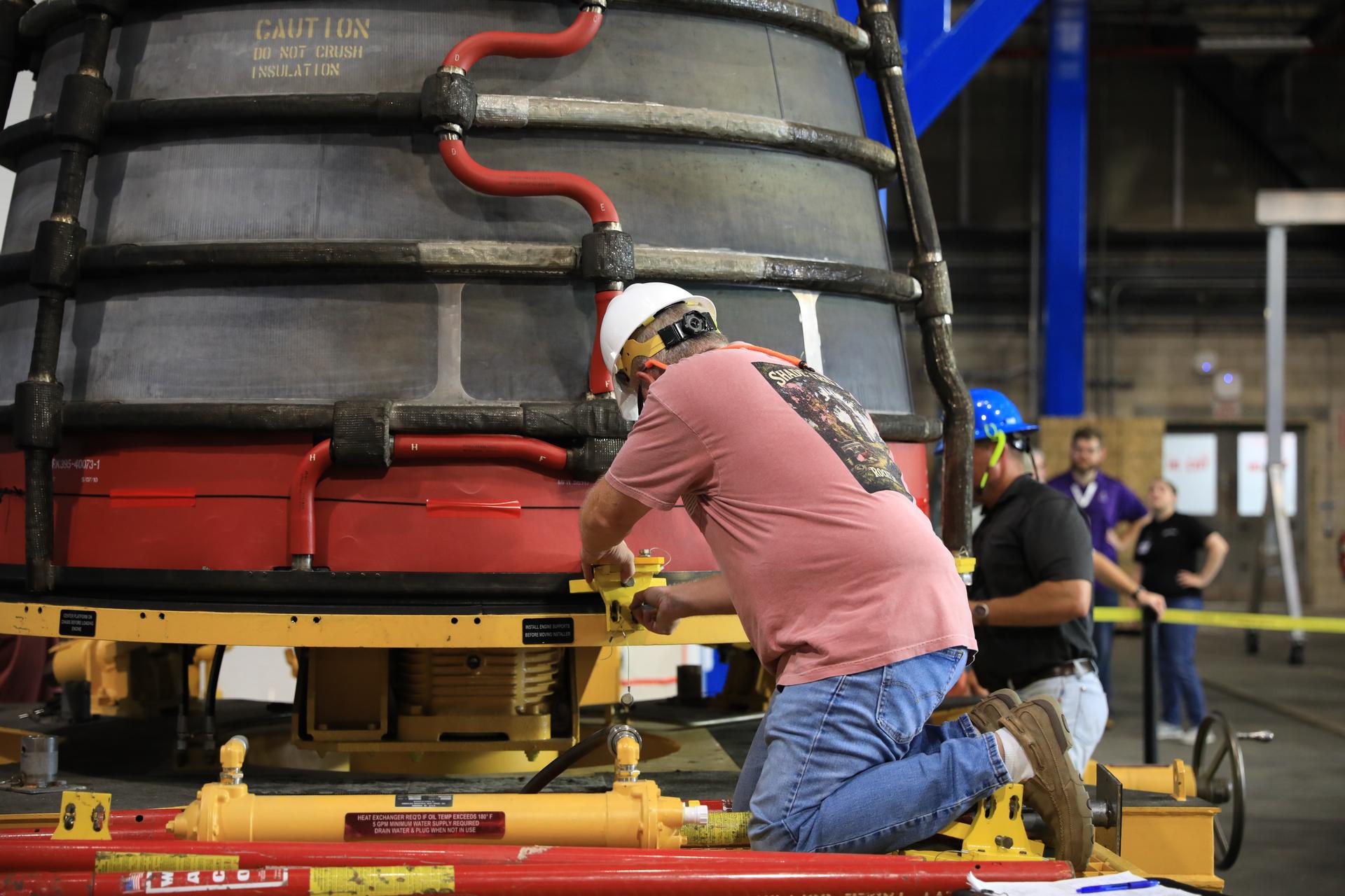 Technicians prepare the #2 RS-25 SLS (Space Launch System) rocket engine for transfer onto a work stand ahead of integration with the Artemis III core stage rocket on Tuesday, Aug. 25, 2026, inside the Vehicle Assembly Building at NASA’s Kennedy Space Center in Florida. During Artemis III, the four RS‑25 engines will launch the Orion spacecraft and its crew of four into low Earth orbit, generating more than two million pounds of thrust at liftoff. 