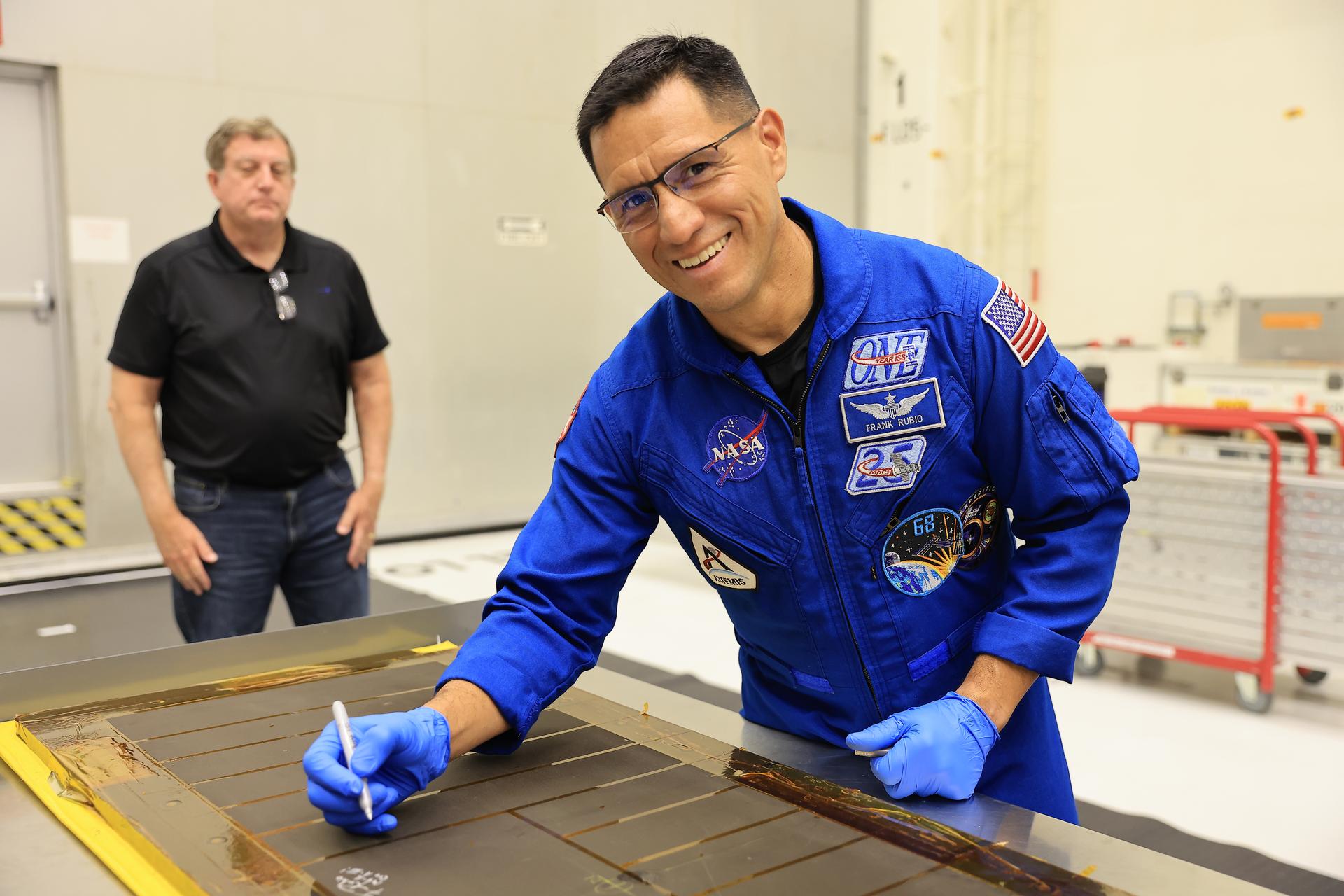 Artemis III NASA astronaut Frank Rubio, mission specialist, signs an interior center wall panel that will cover environmental control and life support system (ECLSS) components inside the Orion crew module in the Neil A. Armstrong Operations and Checkout Building at Kennedy Space Center in Florida on Wednesday, Sept. 2, 2026. The Artemis III primary and backup crew members, including Rubio; NASA astronaut Randy Bresnik, commander; ESA (European Space Agency) astronaut Luca Parmitano, pilot; NASA astronaut Andre Douglas, mission specialist; and NASA astronaut Bob Hines, backup crew member, visited Kennedy to view progress on Artemis III hardware, marking the first visit by the entire crew and backup crew to the Florida spaceport. On Orion, ECLSS will make the crew module a habitable, safe place for astronauts and is key to survival as they travel on deep space missions.
