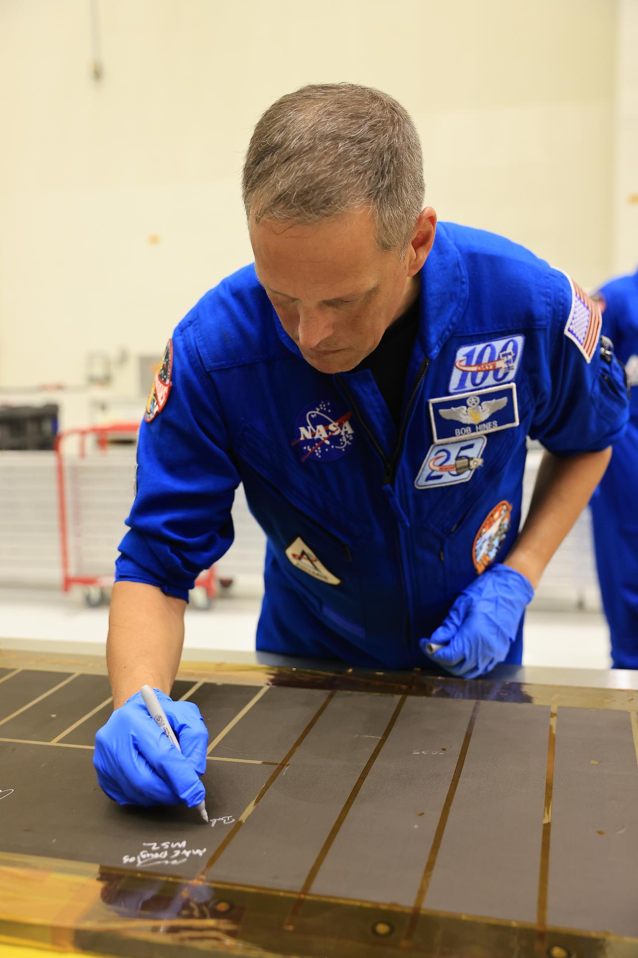 Artemis III NASA astronaut Bob Hines, backup crew member, signs an interior center wall panel that will cover environmental control and life support system (ECLSS) components inside the Orion crew module in the Neil A. Armstrong Operations and Checkout Building at Kennedy Space Center in Florida on Wednesday, Sept. 2, 2026. The Artemis III primary and backup crew members, including Hines; NASA astronaut Randy Bresnik, commander; ESA (European Space Agency) astronaut Luca Parmitano, pilot; NASA astronaut Andre Douglas, mission specialist; NASA astronaut Frank Rubio, mission specialist, visited Kennedy to view progress on Artemis III hardware, marking the first visit by the entire crew and backup crew to the Florida spaceport. On Orion, ECLSS will make the crew module a habitable, safe place for astronauts and is key to survival as they travel on deep space missions.