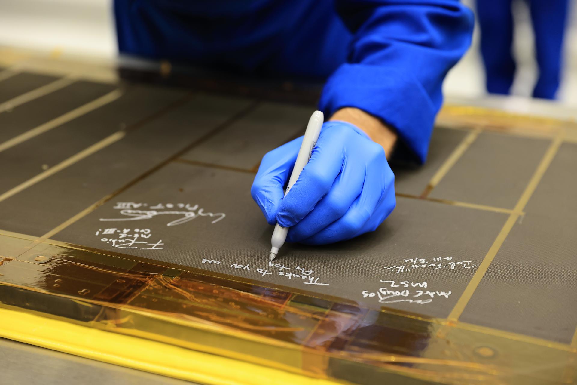 Artemis III NASA astronaut Randy Bresnik, commander, signs an interior center wall panel that will cover environmental control and life support system (ECLSS) components inside the Orion crew module in the Neil A. Armstrong Operations and Checkout Building at Kennedy Space Center in Florida on Wednesday, Sept. 2, 2026. The Artemis III primary and backup crew members, including Bresnik; ESA (European Space Agency) astronaut Luca Parmitano, pilot; NASA astronaut Andre Douglas, mission specialist; NASA astronaut Frank Rubio, mission specialist; and NASA astronaut Bob Hines, backup crew member, visited Kennedy to view progress on Artemis III hardware, marking the first visit by the entire crew and backup crew to the Florida spaceport. On Orion, ECLSS will make the crew module a habitable, safe place for astronauts and is key to survival as they travel on deep space missions.