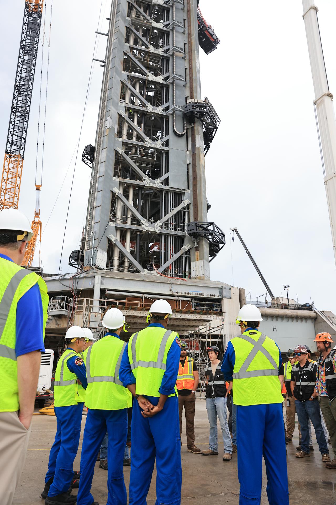 NASA’s Artemis III crew visits Launch Complex 39A at Kennedy Space Center in Florida on Thursday, Sept. 3, 2026, and speaks with members of SpaceX’s pad support team. Wearing hard hats and reflective vests over their blue flight suits, from left, NASA astronauts Frank Rubio, Randy Bresnik, ESA (European Space Agency) astronaut Luca Parmitano, and NASA astronauts Andre Douglas and Bob Hines visited facilities around Kennedy and viewed progress on Artemis III hardware and ground systems. This marked the first visit to Kennedy by the entire crew and backup crew members. Artemis III will launch four crew members aboard the Orion spacecraft to carry out a series of objectives in low Earth orbit designed to demonstrate critical systems needed for future lunar landings, beginning with Artemis IV.
