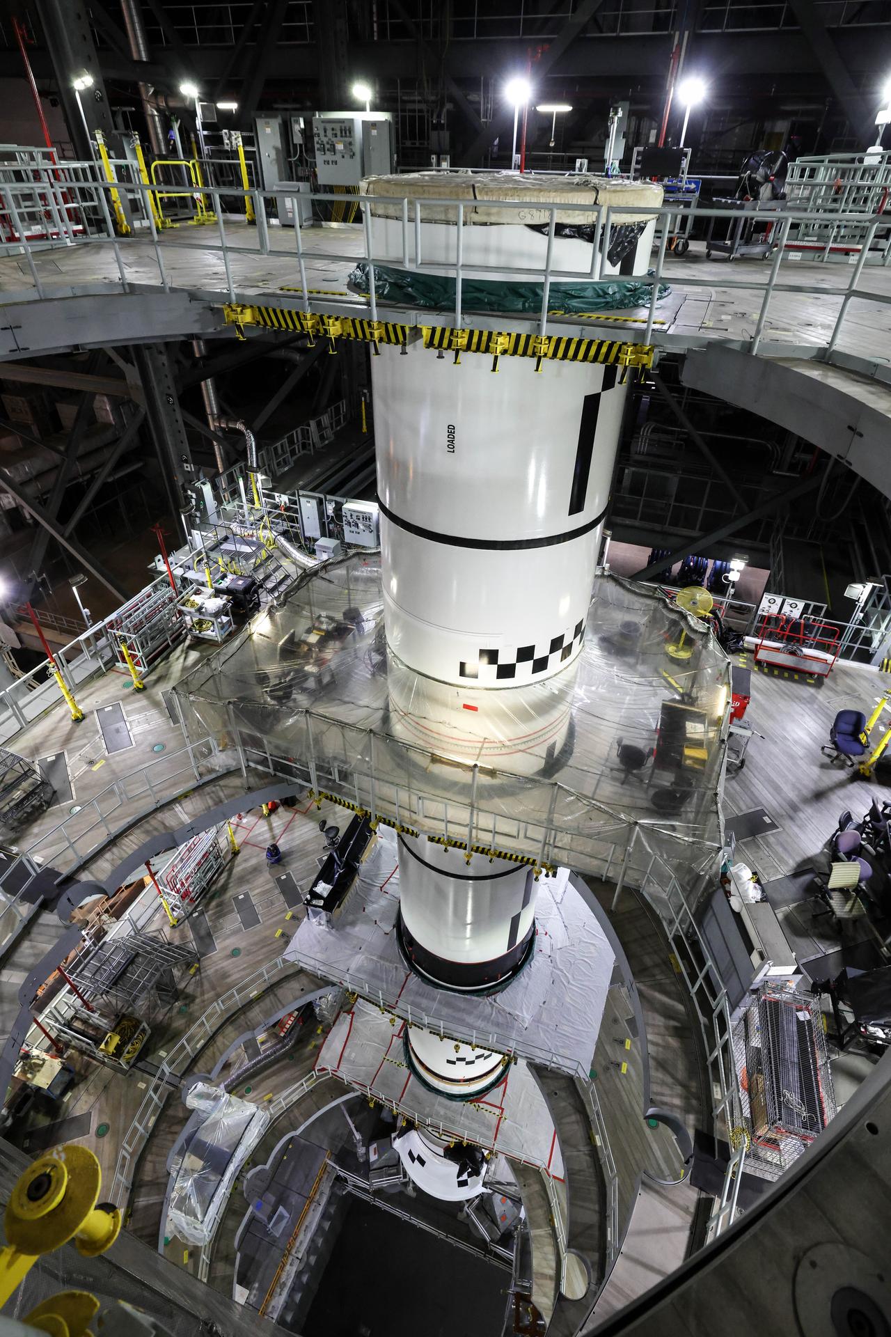 In High Bay 3 of the Vehicle Assembly Building at NASA’s Kennedy Space Center in Florida, the right forward center booster for Artemis III is integrated onto the right booster segments on the mobile launcher for the SLS (Space Launch System) rocket on Friday, Sept. 11, 2026. The twin boosters, comprising of five segments each manufactured by Northrop Grumman in Utah, will provide more than 75 percent of the SLS rocket’s total thrust at launch. The Artemis III mission will launch crew in the Orion spacecraft on top of the SLS rocket to test rendezvous and docking capabilities between Orion and commercial spacecraft needed to land astronauts on the Moon. 