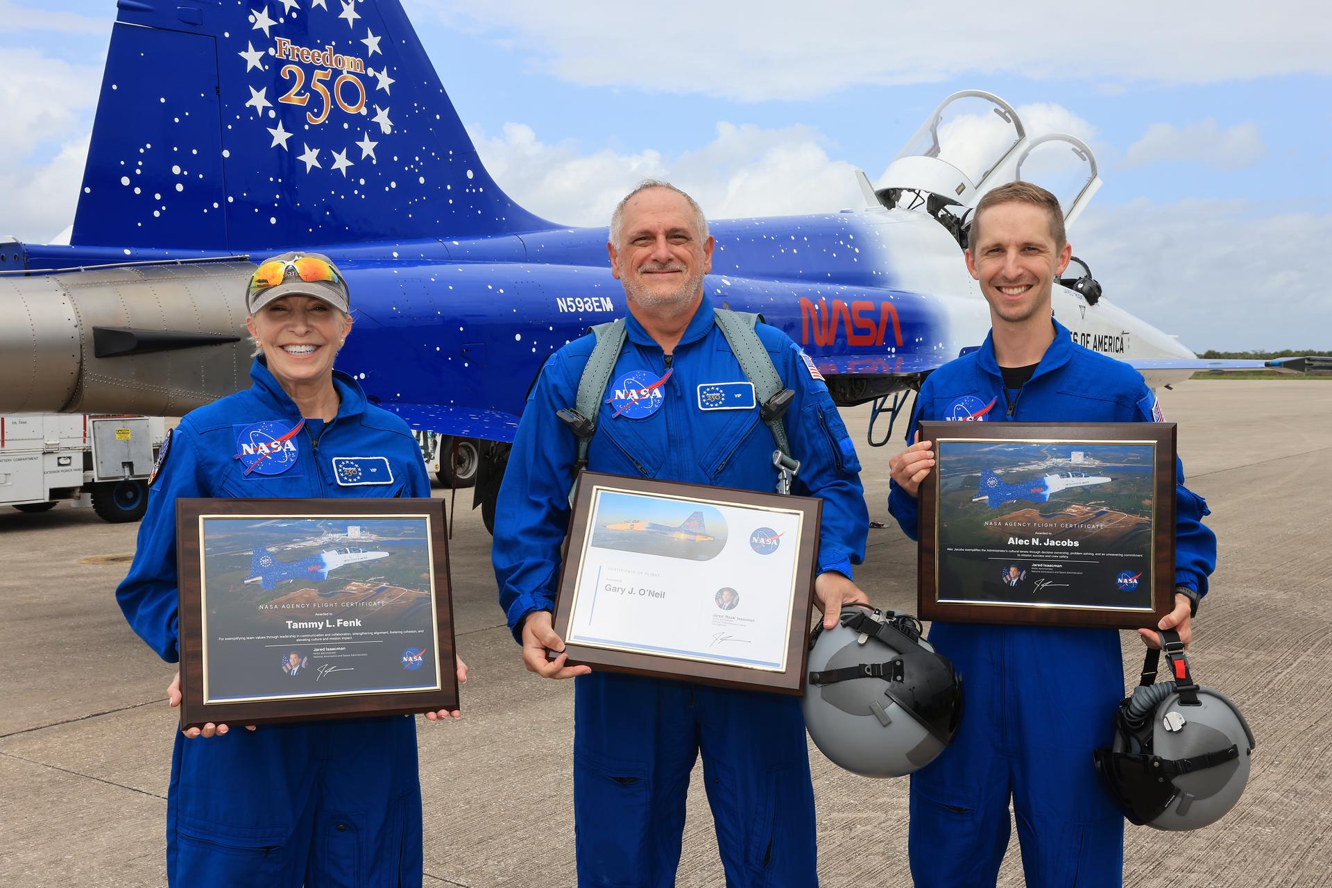 From left, NASA employees Tammy Fenk, Gary O’Neil, and Alec Jacobs pose for a photograph after participating in an employee incentive flying event using NASA Administrator Jared Isaacman's personal F-5 aircraft, Thursday, Sept. 17, 2026, at NASA’s Kennedy Space Center in Florida. As part of the agency’s Flight Experience Award program, the employees donned NASA flight suits, completed preflight briefings, and experienced a unique flight. The ride-along flight experience award program highlights NASA’s commitment to celebrating excellence across the workforce.