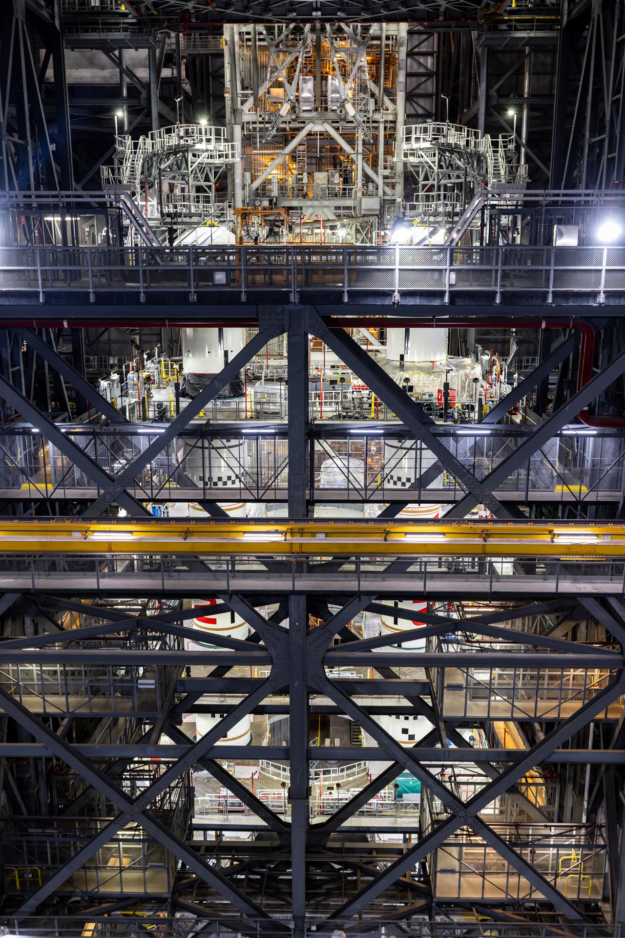 In High Bay 3 of the Vehicle Assembly Building at NASA’s Kennedy Space Center in Florida, the final left and right forward solid rocket booster motor segments for Artemis III are integrated onto the mobile launcher for the SLS (Space Launch System) rocket on Thursday, Sept. 24, 2026. The twin boosters, consisting of five segments each manufactured by Northrop Grumman in Utah, will provide more than 75 percent of the SLS rocket’s total thrust at launch. The Artemis III mission will launch crew in the Orion spacecraft on top of the SLS rocket to test rendezvous and docking capabilities between Orion and commercial spacecraft needed to land astronauts on the Moon.