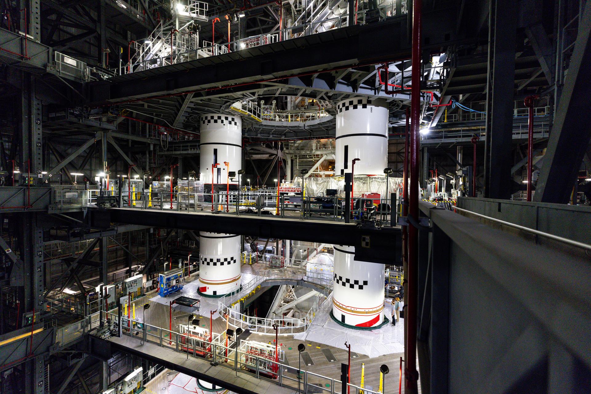 In High Bay 3 of the Vehicle Assembly Building at NASA’s Kennedy Space Center in Florida, the final left and right forward solid rocket booster motor segments for Artemis III are integrated onto the mobile launcher for the SLS (Space Launch System) rocket on Thursday, Sept. 24, 2026. The twin boosters, consisting of five segments each manufactured by Northrop Grumman in Utah, will provide more than 75 percent of the SLS rocket’s total thrust at launch. The Artemis III mission will launch crew in the Orion spacecraft on top of the SLS rocket to test rendezvous and docking capabilities between Orion and commercial spacecraft needed to land astronauts on the Moon.