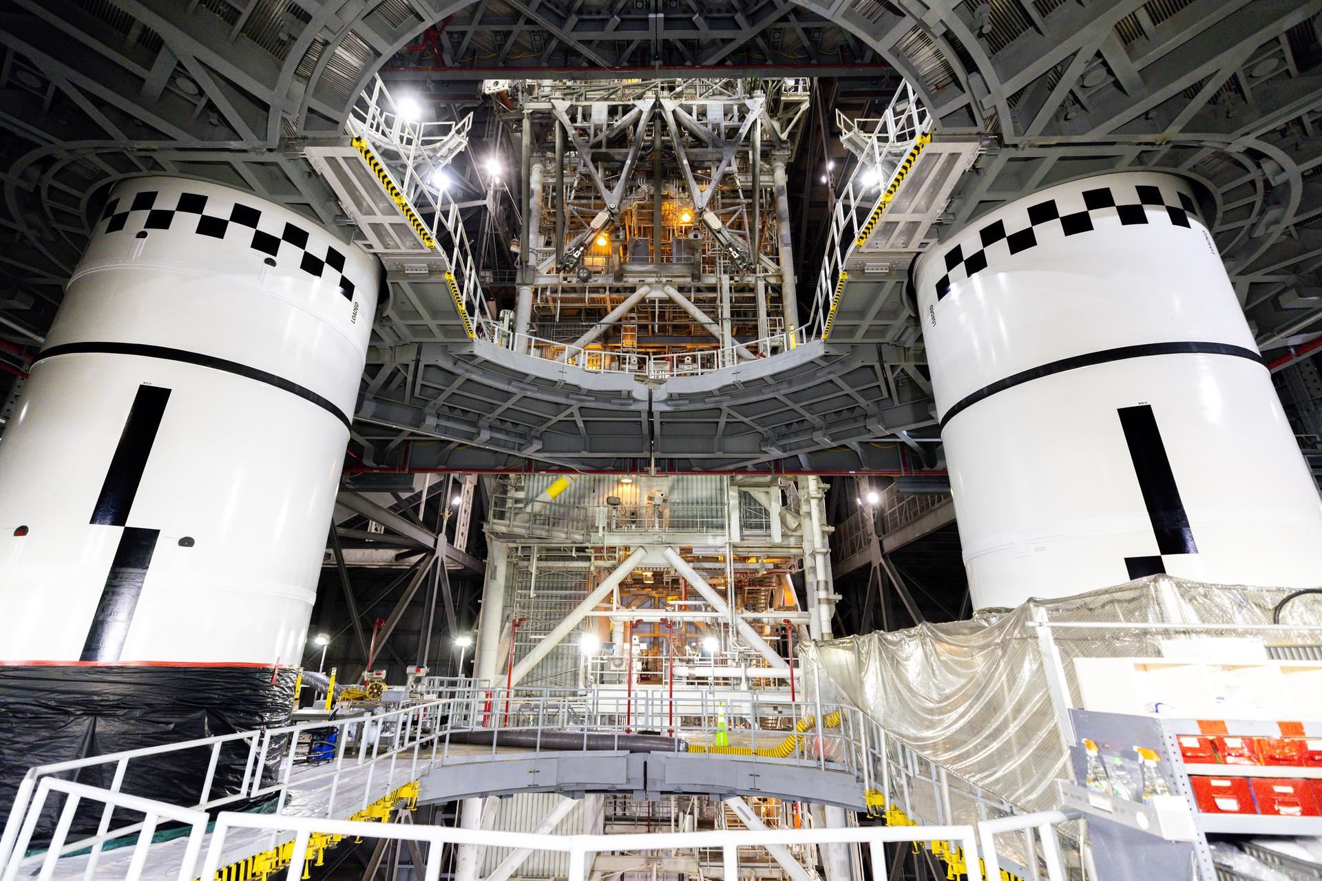 In High Bay 3 of the Vehicle Assembly Building at NASA’s Kennedy Space Center in Florida, the final left and right forward solid rocket booster motor segments for Artemis III are integrated onto the mobile launcher for the SLS (Space Launch System) rocket on Thursday, Sept. 24, 2026. The twin boosters, consisting of five segments each manufactured by Northrop Grumman in Utah, will provide more than 75 percent of the SLS rocket’s total thrust at launch. The Artemis III mission will launch crew in the Orion spacecraft on top of the SLS rocket to test rendezvous and docking capabilities between Orion and commercial spacecraft needed to land astronauts on the Moon.
