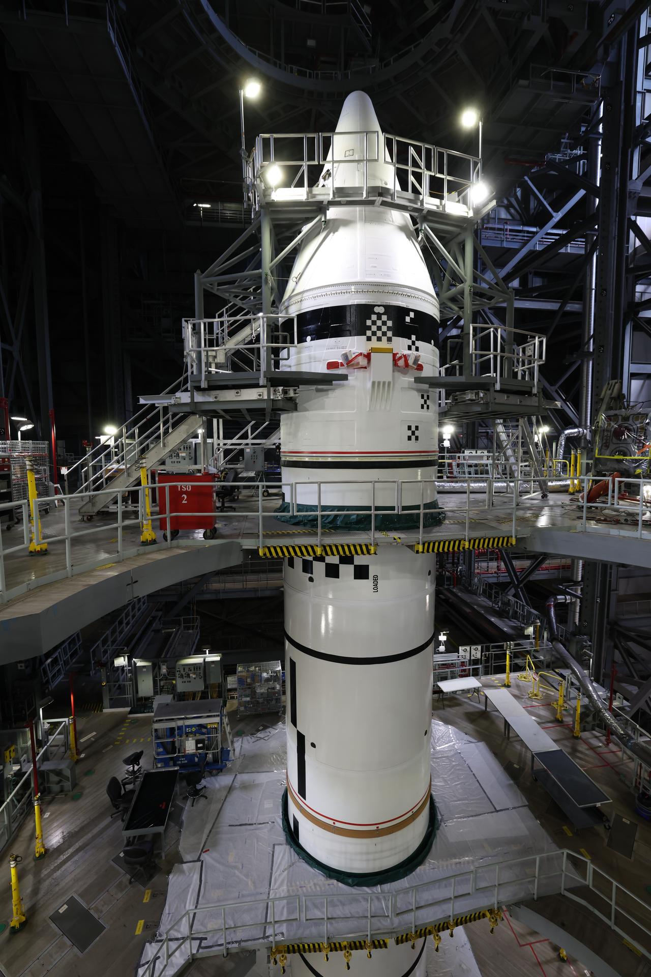 Engineers with NASA’s Exploration Ground Systems integrate the aerodynamic nose cone onto the left forward motor segment on the twin SLS (Space Launch System) solid rocket boosters for Artemis III inside the Vehicle Assembly Building’s High Bay 3 at NASA’s Kennedy Space Center in Florida on Tuesday, Sept. 29, 2026. Each forward assembly contains an aerodynamic top, a forward skirt housing avionics, and frustum housing motors that allow the boosters to separate from the SLS core stage after launch. The twin solid boosters will help support the remaining rocket components and the Orion spacecraft during final assembly of the Artemis III rocket and provide more than 75 percent of the total SLS thrust during liftoff from NASA Kennedy’s Launch Pad 39B.