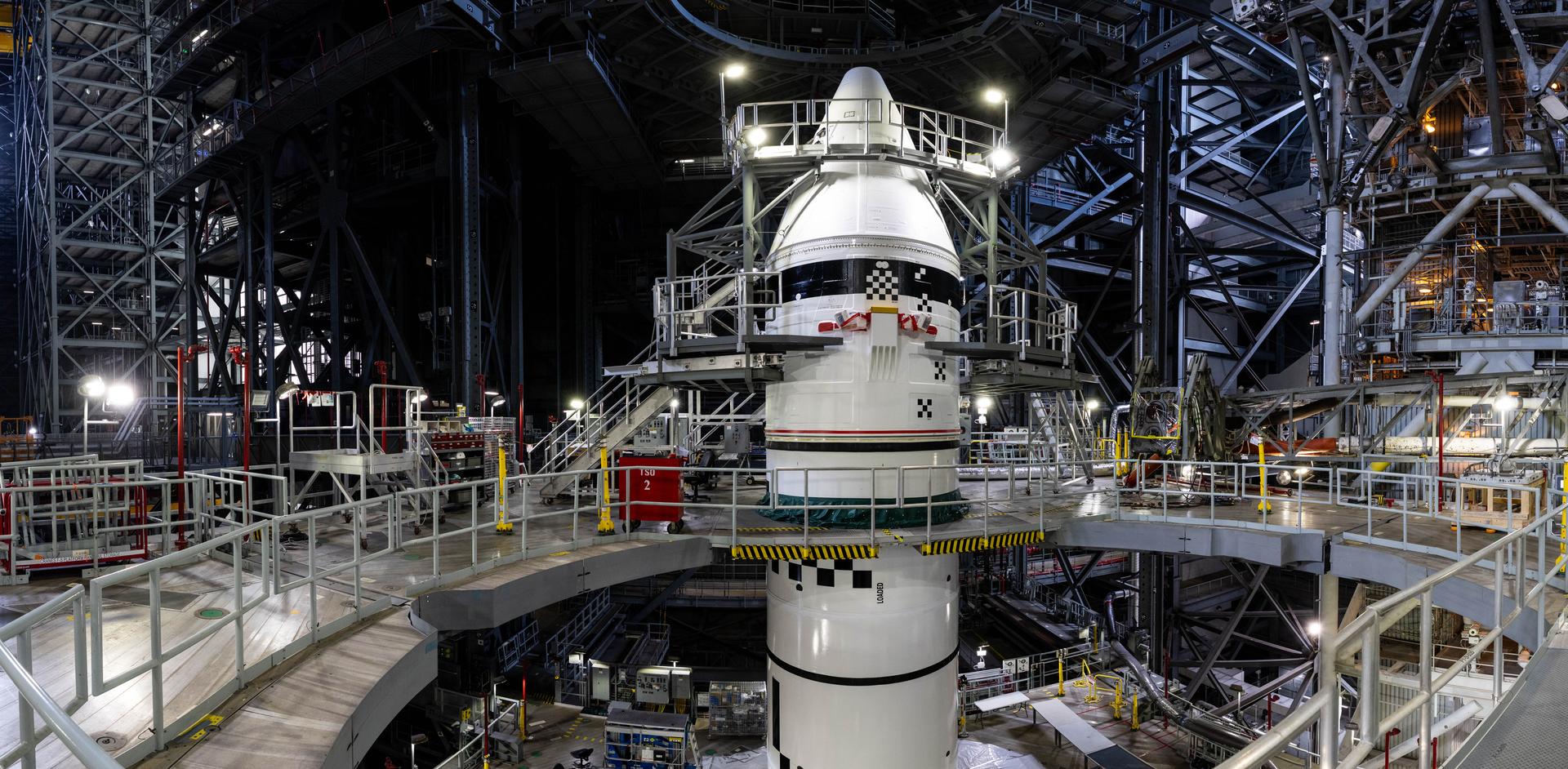 Engineers with NASA’s Exploration Ground Systems integrate the aerodynamic nose cone onto the left forward motor segment on the twin SLS (Space Launch System) solid rocket boosters for Artemis III inside the Vehicle Assembly Building’s High Bay 3 at NASA’s Kennedy Space Center in Florida on Tuesday, Sept. 29, 2026. Each forward assembly contains an aerodynamic top, a forward skirt housing avionics, and frustum housing motors that allow the boosters to separate from the SLS core stage after launch. The twin solid boosters will help support the remaining rocket components and the Orion spacecraft during final assembly of the Artemis III rocket and provide more than 75 percent of the total SLS thrust during liftoff from NASA Kennedy’s Launch Pad 39B.