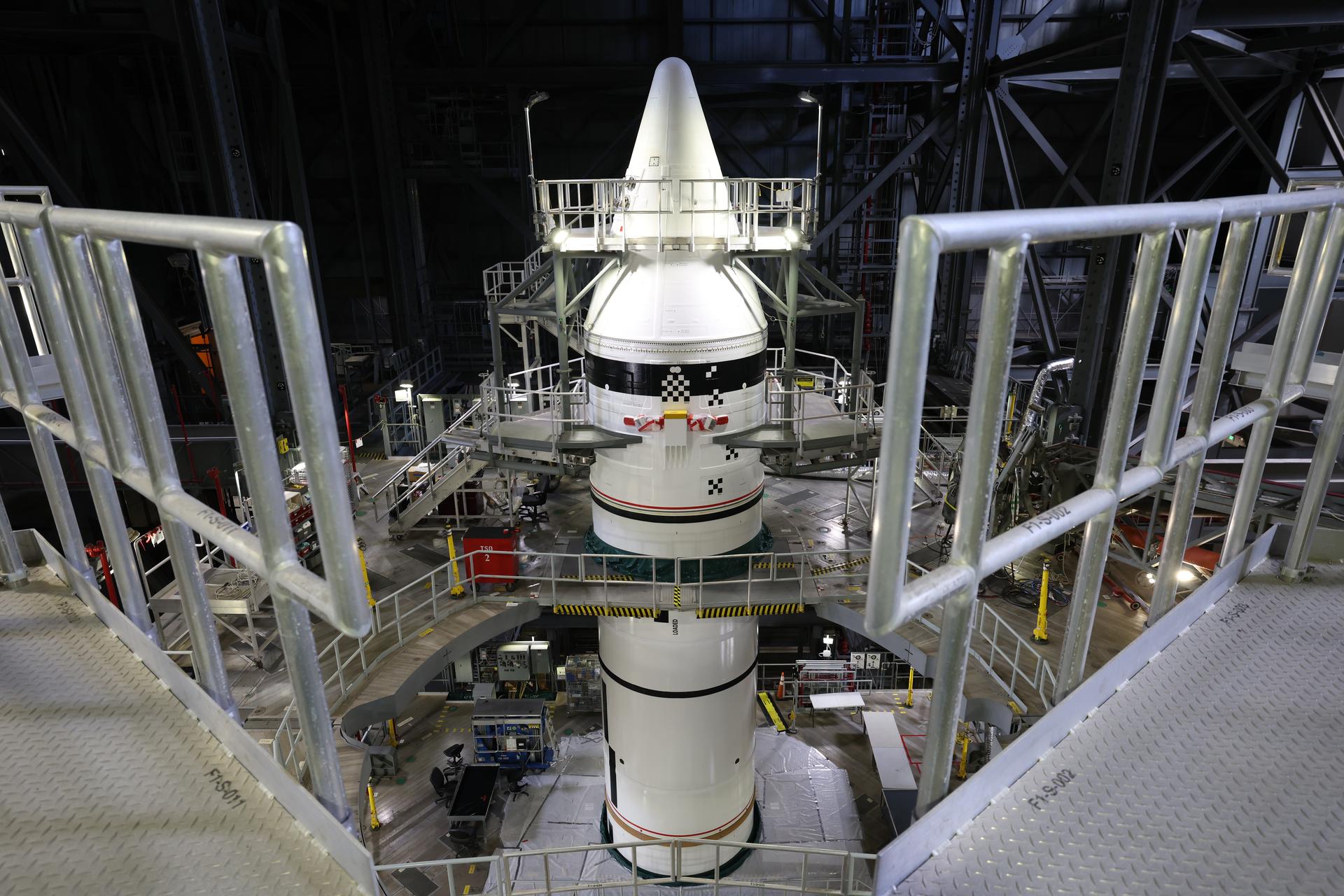 Engineers with NASA’s Exploration Ground Systems integrate the aerodynamic nose cone onto the left forward motor segment on the twin SLS (Space Launch System) solid rocket boosters for Artemis III inside the Vehicle Assembly Building’s High Bay 3 at NASA’s Kennedy Space Center in Florida on Tuesday, Sept. 29, 2026. Each forward assembly contains an aerodynamic top, a forward skirt housing avionics, and frustum housing motors that allow the boosters to separate from the SLS core stage after launch. The twin solid boosters will help support the remaining rocket components and the Orion spacecraft during final assembly of the Artemis III rocket and provide more than 75 percent of the total SLS thrust during liftoff from NASA Kennedy’s Launch Pad 39B.