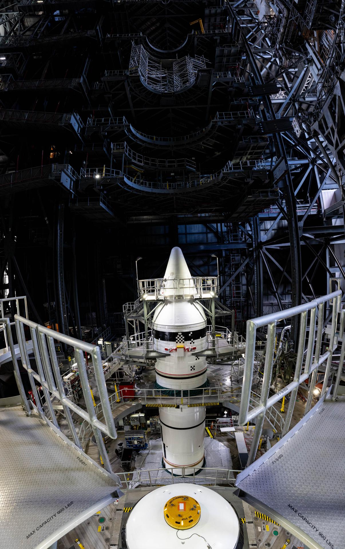 Engineers with NASA’s Exploration Ground Systems integrate the aerodynamic nose cone onto the left forward motor segment on the twin SLS (Space Launch System) solid rocket boosters for Artemis III inside the Vehicle Assembly Building’s High Bay 3 at NASA’s Kennedy Space Center in Florida on Tuesday, Sept. 29, 2026. Each forward assembly contains an aerodynamic top, a forward skirt housing avionics, and frustum housing motors that allow the boosters to separate from the SLS core stage after launch. The twin solid boosters will help support the remaining rocket components and the Orion spacecraft during final assembly of the Artemis III rocket and provide more than 75 percent of the total SLS thrust during liftoff from NASA Kennedy’s Launch Pad 39B.