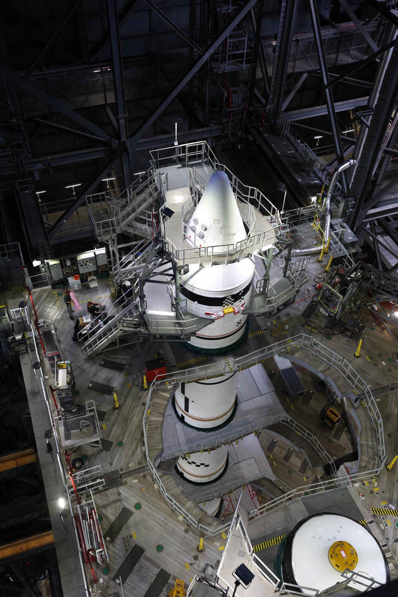 Engineers with NASA’s Exploration Ground Systems integrate the aerodynamic nose cone onto the left forward motor segment on the twin SLS (Space Launch System) solid rocket boosters for Artemis III inside the Vehicle Assembly Building’s High Bay 3 at NASA’s Kennedy Space Center in Florida on Tuesday, Sept. 29, 2026. Each forward assembly contains an aerodynamic top, a forward skirt housing avionics, and frustum housing motors that allow the boosters to separate from the SLS core stage after launch. The twin solid boosters will help support the remaining rocket components and the Orion spacecraft during final assembly of the Artemis III rocket and provide more than 75 percent of the total SLS thrust during liftoff from NASA Kennedy’s Launch Pad 39B.
