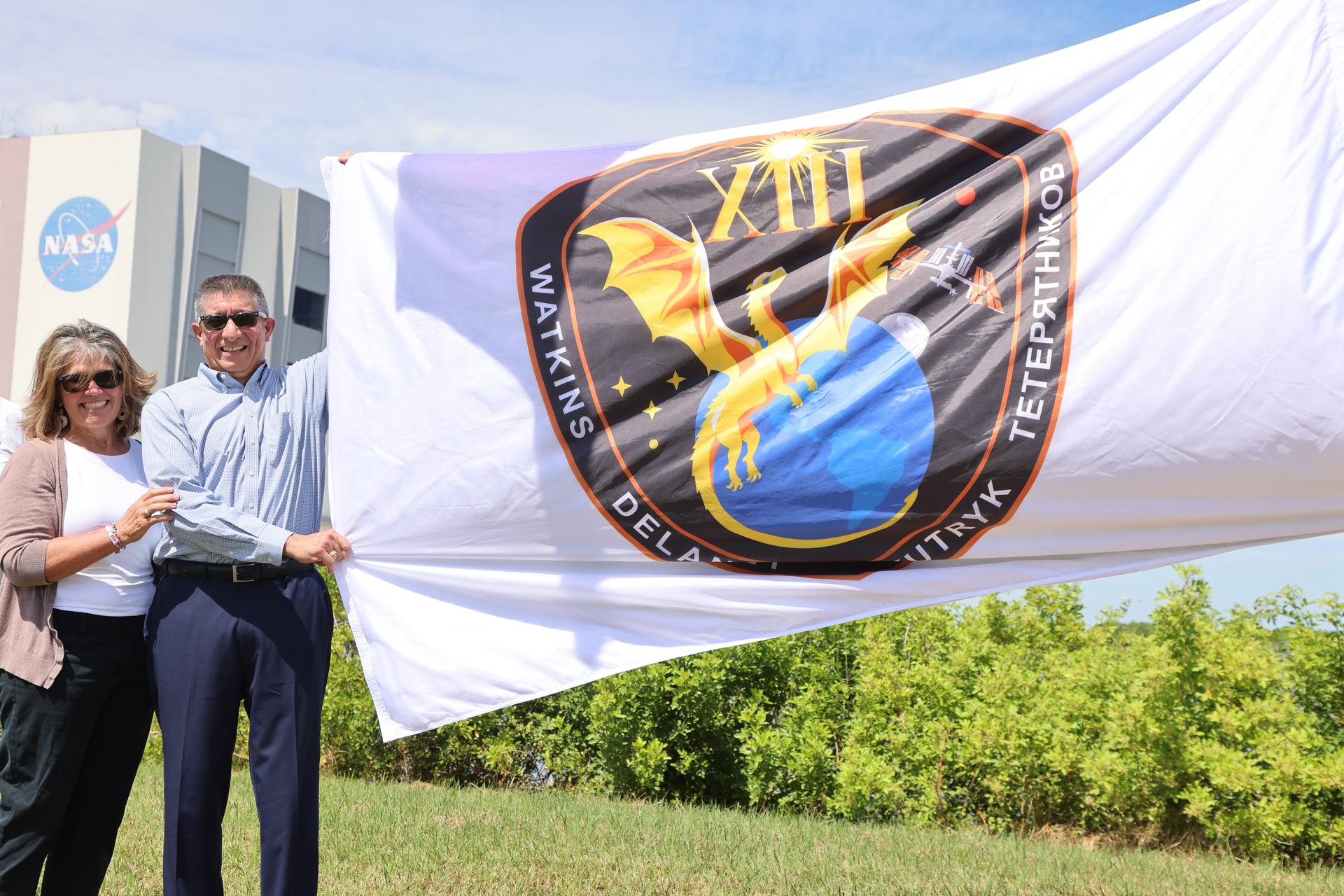 From left to right, Jennifer Jones, and Richard Jones, deputy program manager, Commercial Crew Office of Low Earth Orbit Program, raise the agency’s SpaceX Crew-13 mission flag near the countdown clock at the NASA News Center at the agency’s Kennedy Space Center in Florida on Tuesday, Sept. 29, 2026. The Crew-13 mission will send NASA astronauts Jessica Watkins and Luke Delaney, CSA (Canadian Space Agency) astronaut Joshua Kutryk, and Roscosmos cosmonaut Sergey Teteryatnikov to the International Space Station aboard SpaceX’s Dragon spacecraft and Falcon 9 rocket at 11:10 a.m. EDT on Thursday, Oct. 1, from Cape Canaveral Space Force Station’s Space Launch Complex 40.