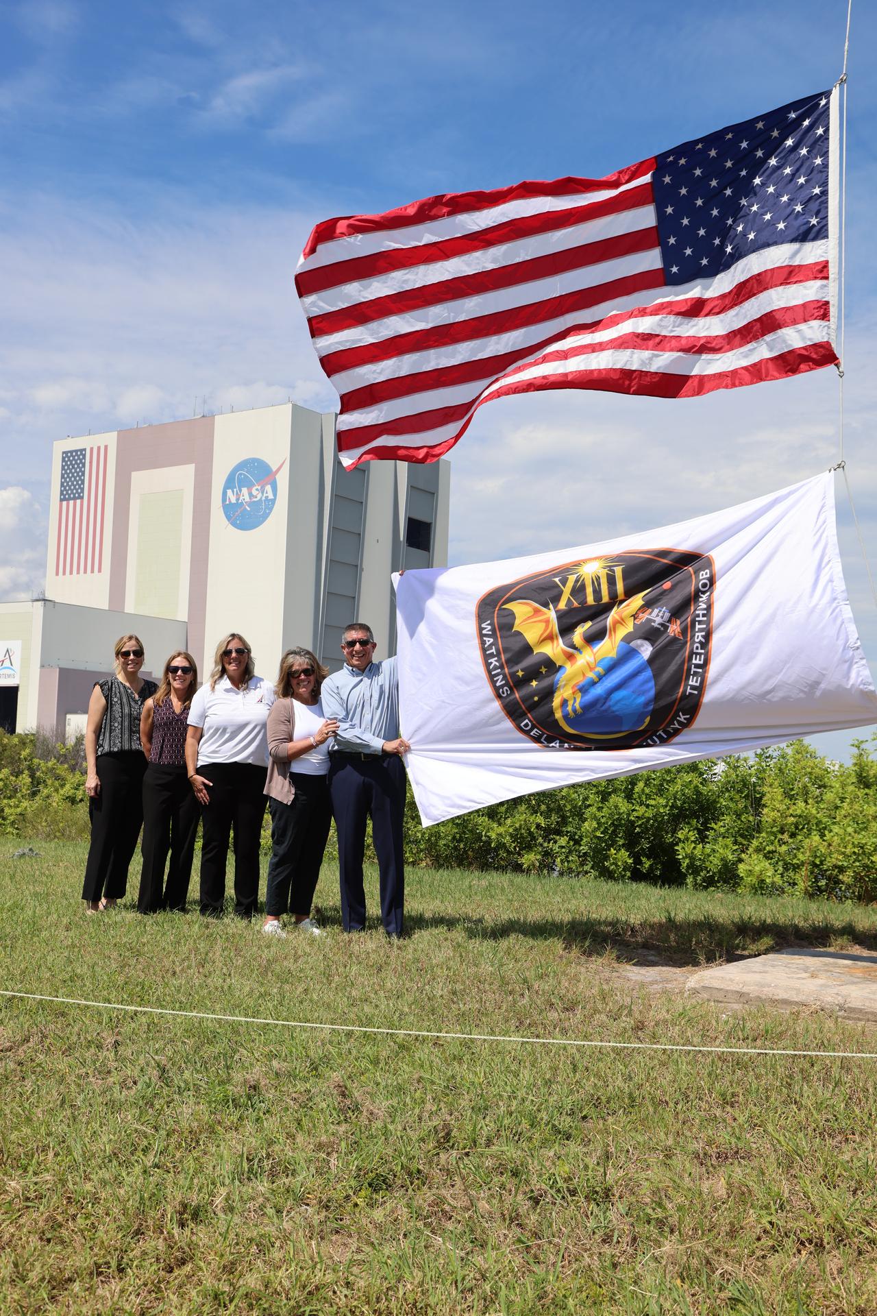From left to right, Mary Lawrence, director Commercial Crew Office; Dana Weigel, manager, Low Earth Orbit Program; Dana Hutcherson, deputy director, Commercial Crew Office; Jennifer Jones, and Richard Jones, deputy program manager, Commercial Crew Office of Low Earth Orbit Program, raise the agency’s SpaceX Crew-13 mission flag near the countdown clock at the NASA News Center at the agency’s Kennedy Space Center in Florida on Tuesday, Sept. 29, 2026. The Crew-13 mission will send NASA astronauts Jessica Watkins and Luke Delaney, CSA (Canadian Space Agency) astronaut Joshua Kutryk, and Roscosmos cosmonaut Sergey Teteryatnikov to the International Space Station aboard SpaceX’s Dragon spacecraft and Falcon 9 rocket at 11:10 a.m. EDT on Thursday, Oct. 1, from Cape Canaveral Space Force Station’s Space Launch Complex 40.