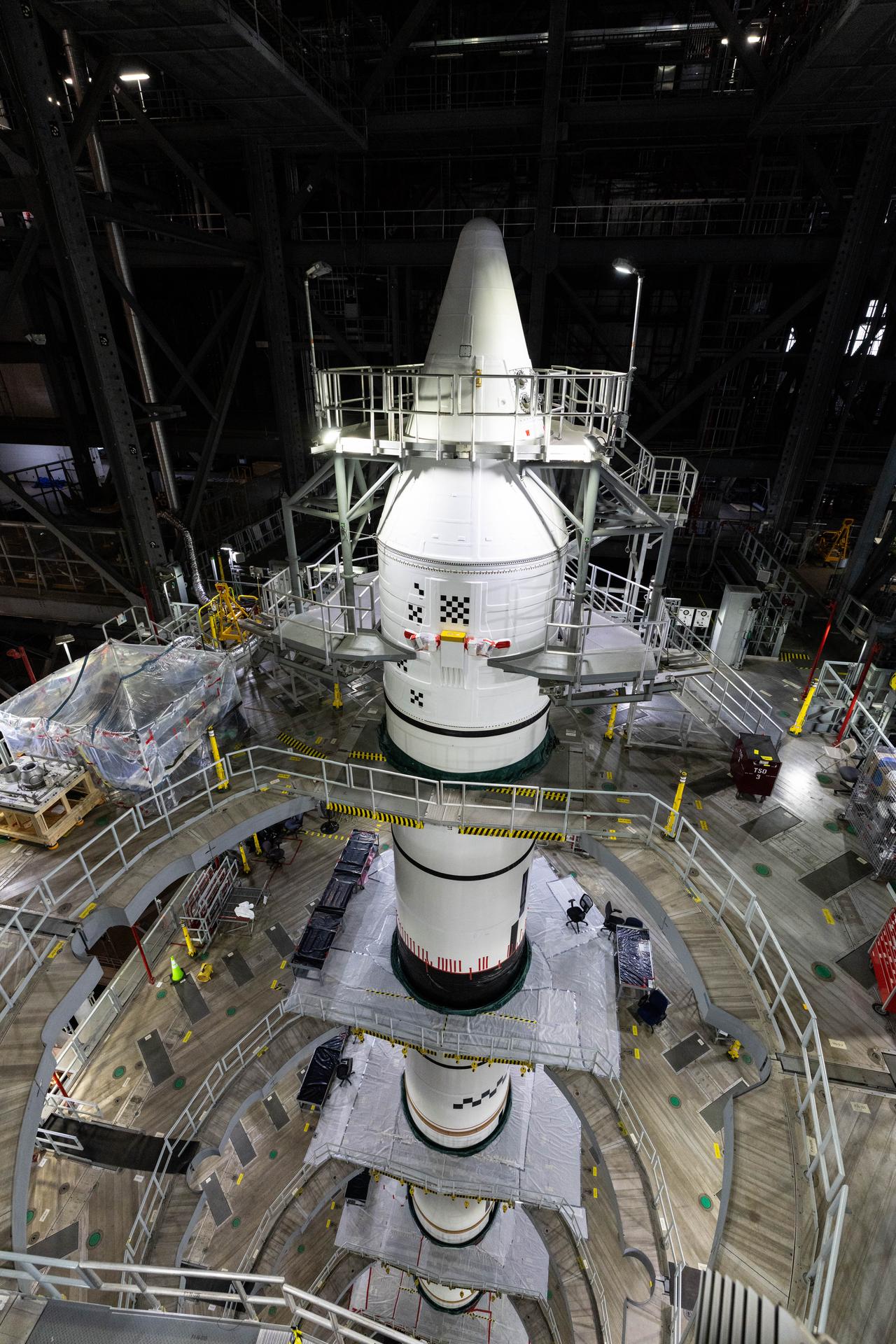 Engineers with NASA’s Exploration Ground Systems integrate the aerodynamic nose cone onto the right forward motor segment on the twin SLS (Space Launch System) solid rocket boosters for Artemis III inside the Vehicle Assembly Building’s High Bay 3 at NASA’s Kennedy Space Center in Florida on Wednesday, Sept. 30, 2026. Each forward assembly contains an aerodynamic top, a forward skirt housing avionics, and frustum housing motors that allow the boosters to separate from the SLS core stage after launch. The twin solid boosters will help support the remaining rocket components and the Orion spacecraft during final assembly of the Artemis III rocket and provide more than 75 percent of the total SLS thrust during liftoff from NASA Kennedy’s Launch Pad 39B.