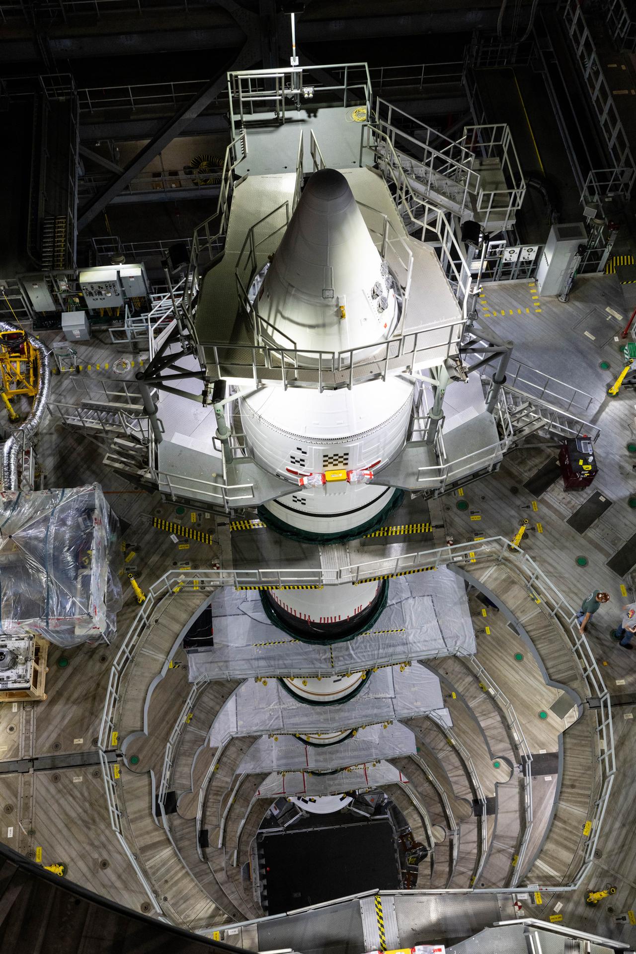 Engineers with NASA’s Exploration Ground Systems integrate the aerodynamic nose cone onto the right forward motor segment on the twin SLS (Space Launch System) solid rocket boosters for Artemis III inside the Vehicle Assembly Building’s High Bay 3 at NASA’s Kennedy Space Center in Florida on Wednesday, Sept. 30, 2026. Each forward assembly contains an aerodynamic top, a forward skirt housing avionics, and frustum housing motors that allow the boosters to separate from the SLS core stage after launch. The twin solid boosters will help support the remaining rocket components and the Orion spacecraft during final assembly of the Artemis III rocket and provide more than 75 percent of the total SLS thrust during liftoff from NASA Kennedy’s Launch Pad 39B.
