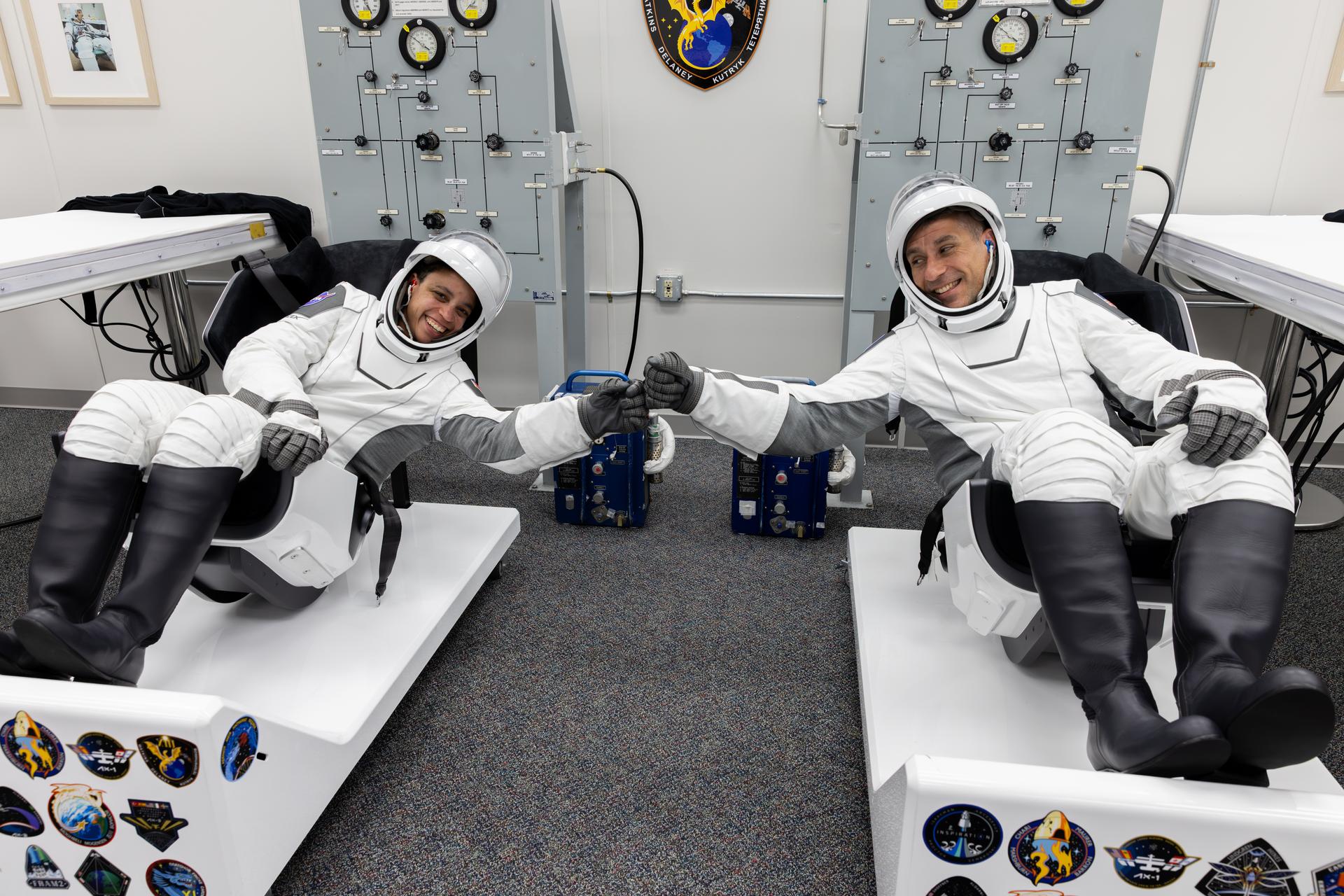 From left to right, NASA astronauts Jessica Watkins and Luke Delaney fist bump during suit leak checks for their SpaceX spacesuits inside the crew suit-up room in the Neil A. Armstrong Operations and Checkout Building at the agency’s Kennedy Space Center in Florida ahead of launch of NASA’s SpaceX Crew-13 mission to the International Space Station on Thursday, Oct. 1, 2026. Watkins, Delaney, along with CSA (Canadian Space Agency) astronaut Joshua Kutryk, and Roscosmos cosmonaut Sergey Teteryatnikov are scheduled to lift off aboard SpaceX’s Dragon spacecraft and Falcon 9 rocket no earlier than 11:10 a.m. EDT, from Space Launch Complex 40 at Cape Canaveral Space Force Station in Florida.