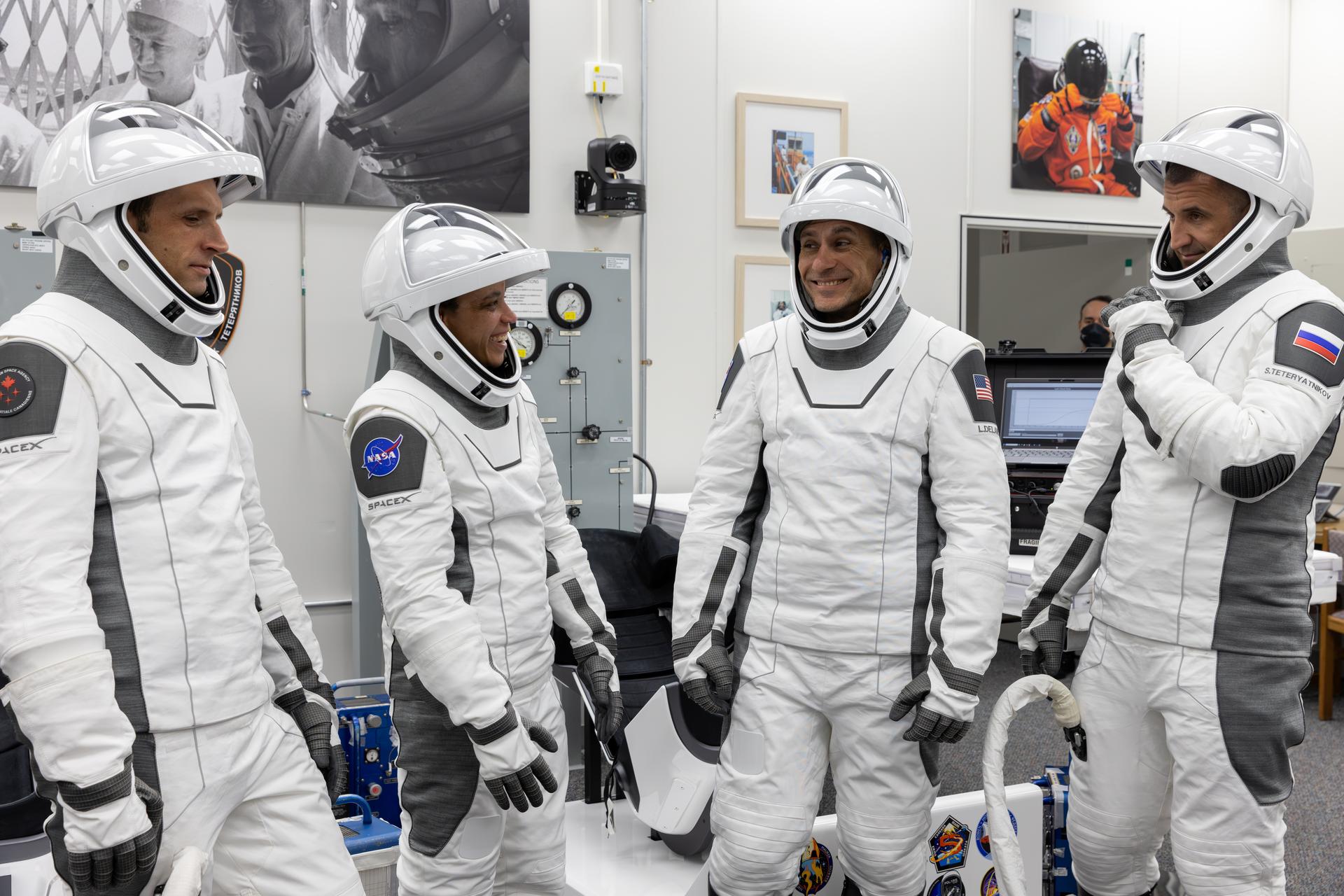 NASA’s SpaceX Crew-13 members stand and talk following the completion of suit leak checks in the Neil A. Armstrong Operations and Checkout Building at the agency’s Kennedy Space Center in Florida ahead of launch to the International Space Station on Thursday, Oct. 1, 2026. From left to right, CSA (Canadian Space Agency) astronaut Joshua Kutryk, and NASA astronauts Jessica Watkins and Luke Delaney, along with Roscosmos cosmonaut Sergey Teteryatnikov are scheduled to lift off aboard SpaceX’s Dragon spacecraft and Falcon 9 rocket no earlier than 11:10 a.m. EDT, from Space Launch Complex 40 at Cape Canaveral Space Force Station in Florida.