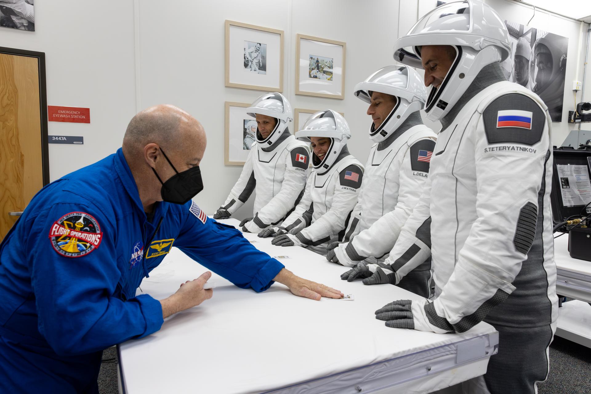 NASA’s SpaceX Crew-13 crew members play the traditional card game with NASA astronaut chief Scott Tingle, inside the Neil A. Armstrong Operations and Checkout Building at the agency’s Kennedy Space Center in Florida ahead of launch to the International Space Station on Thursday, Oct. 1, 2026. From left to right, CSA (Canadian Space Agency) astronaut Joshua Kutryk, and NASA astronauts Jessica Watkins and Luke Delaney, along with Roscosmos cosmonaut Sergey Teteryatnikov are scheduled to lift off aboard SpaceX’s Dragon spacecraft and Falcon 9 rocket no earlier than 11:10 a.m. EDT, from Space Launch Complex 40 at Cape Canaveral Space Force Station in Florida.