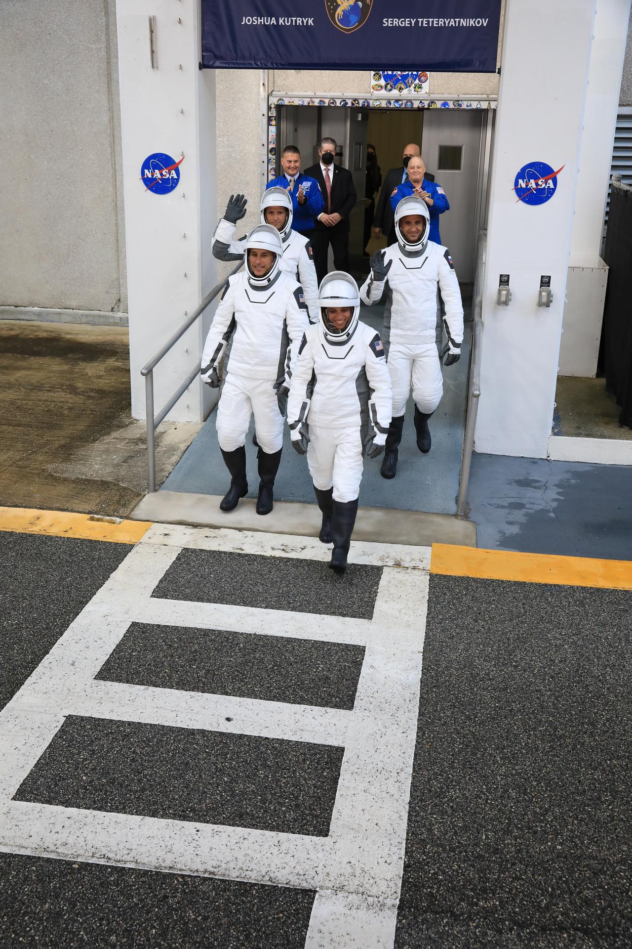 From left to right, NASA astronauts Luke Delaney and Jessica Watkins (front), and CSA (Canadian Space Agency) astronaut Joshua Kutryk, along with Roscosmos cosmonaut Sergey Teteryatnikov (back), wave to family and friends as they prepare to depart the Neil A. Armstrong Operations and Checkout Building at the agency’s Kennedy Space Center in Florida for nearby Space Launch Complex 40 at Cape Canaveral Space Force Station for launch of Crew-13 on Thursday, Oct. 1, 2026. Crew-13 is scheduled to lift off aboard SpaceX’s Dragon spacecraft and Falcon 9 rocket no earlier than 11:10 a.m. EDT, from Space Launch Complex 40 at Cape Canaveral Space Force Station in Florida.