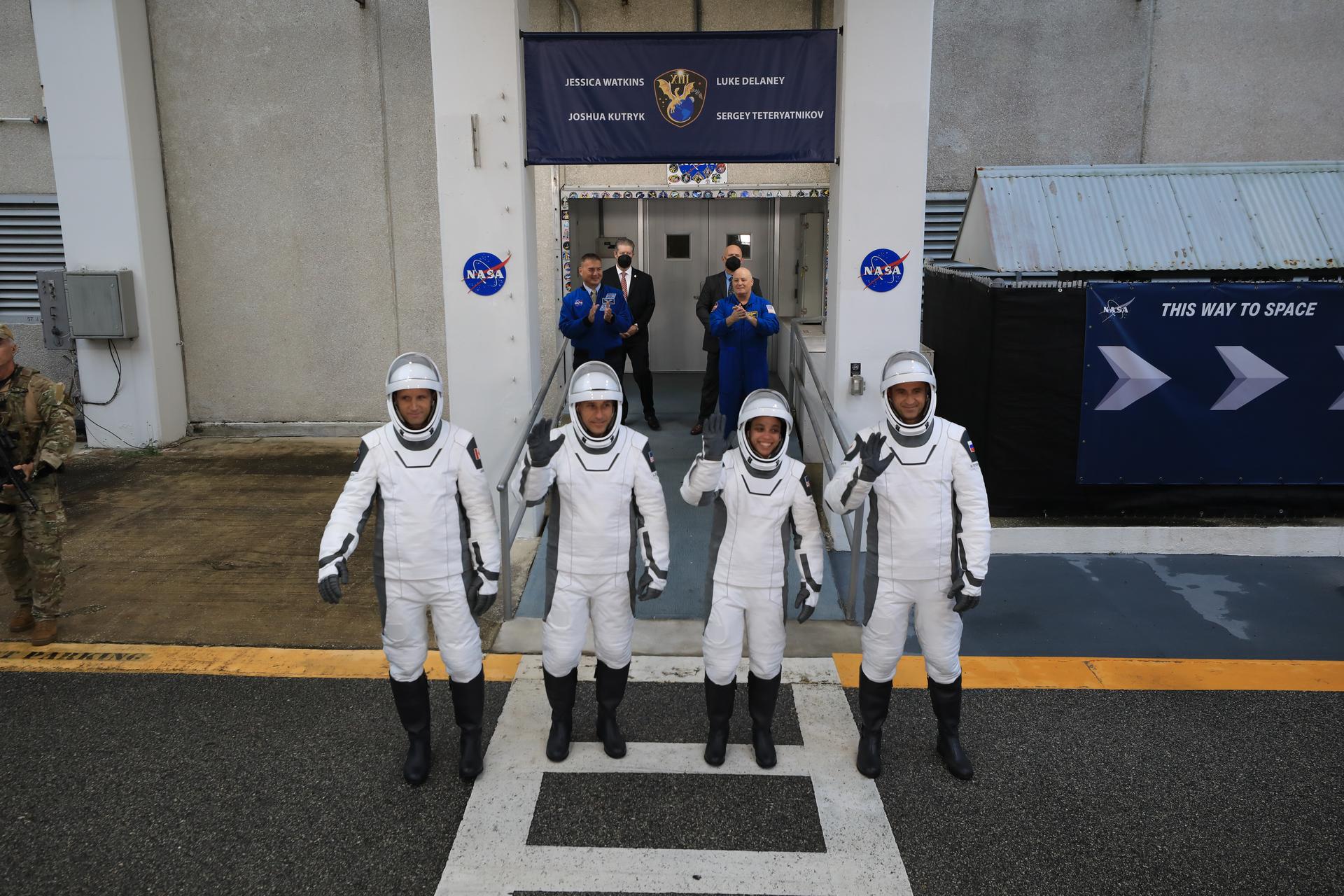 From left to right, NASA astronauts Luke Delaney and Jessica Watkins, along with Roscosmos cosmonaut Sergey Teteryatnikov, and CSA (Canadian Space Agency) astronaut Joshua Kutryk (back), wave to family and friends as they prepare to depart the Neil A. Armstrong Operations and Checkout Building at the agency’s Kennedy Space Center in Florida for nearby Space Launch Complex 40 at Cape Canaveral Space Force Station for launch of Crew-13 on Thursday, Oct. 1, 2026. Crew-13 is scheduled to lift off aboard SpaceX’s Dragon spacecraft and Falcon 9 rocket no earlier than 11:10 a.m. EDT, from Space Launch Complex 40 at Cape Canaveral Space Force Station in Florida.